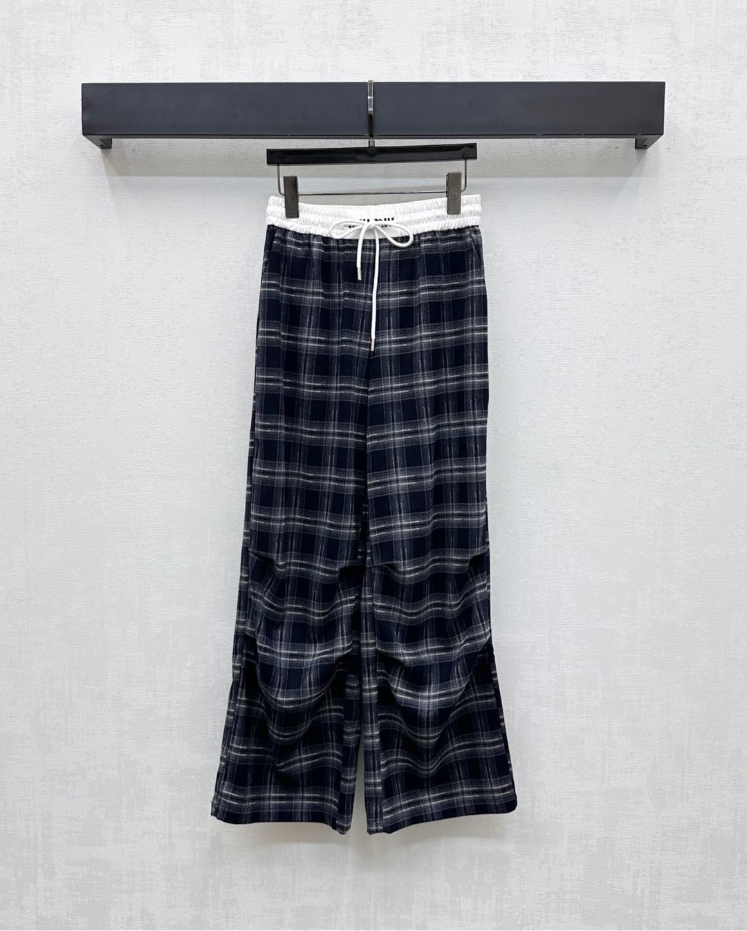 NO:500402,Miumi*2025 new product is on the shelves of plaid pleated drawstring trousers customized with YB imported polyester cotton material. It is soft and skin-friendly, with stronger draping. High-quality plaids are covered with plaids. It is designed with white edge drawstrings on the waist. It is decorated with iconic letter embroidery logos to highlight the brand tone. The pleats at the knees are strong, making the outfit more inclusive. It does not pick on the figure and adds a sense of styling. The surface and auxiliary materials are developed. High-waisted wide-leg trousers are cut. The upper body is fashionable and relaxed. Wearing a fashionable and fashionable dressing style. High version 2 colors,,miumiu,alexander wang19860909Miumi*2025新品上架格纹褶皱抽绳长裤定制YB进口涤棉材质 质感柔软亲肤 垂感更强 品相高级 通体格纹满铺 配合腰间以白色包边抽绳设计 穿插标志性字母刺绣徽标装点 彰显品牌调性 膝盖处褶皱工装感强烈 让穿搭更加包容 不挑身材 增添造型层次感 面辅料开发 高腰阔腿长裤剪裁 上身洋气松弛 穿出时髦流行穿搭风格 高版本2色,,miumiu,alexander wang,Women's clothing