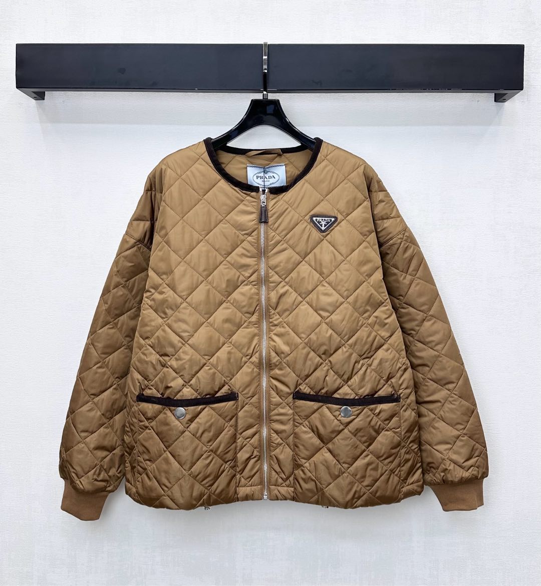 NO:569427,Prad*2025 new arrival round neck cotton jacket customized with YB imported windproof and waterproof nylon material. Down cotton filling inside. The whole piece is light and warm. The whole body is made of rhombus embossing. Contrast color binding and pocket contour processing add to the layering of the look. The iconic triangle logo decoration on the chest highlights the brand tone. Development of surface accessories. Zipper jacket tailoring. Casually match with skirts and trousers to look fashionable. High version 2 colors, prada, skirts, jackets.  & coats,jackets & coats,down jacket,alexander wang19860909Prad*2025新品上架圆领棉服外套定制YB进口防风防水尼龙材质 内里羽绒棉填充 整件轻盈保暖 通体采用菱格压纹 拼接撞色包边与口袋轮廓线处理 增添造型层次感 胸前点缀标志性三角徽标装饰 彰显品牌调性 面辅料开发 拉链夹克外套剪裁 随意搭配裙裤装穿搭时髦洋气 高版本2色,,prada,skirts,jackets & coats,jackets & coats,down jacket,alexander wang,Women's clothing