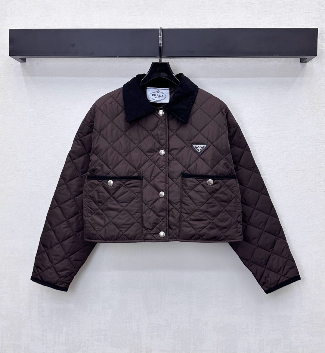 NO:569437,Prad*2025 new products are on the shelves. Corduroy collar cotton jacket is made of YB imported windproof and waterproof nylon material. Down cotton filling inside. The whole piece is light and warm. The whole body is made of diamond embossing. Corduroy splicing collar design. It is matched with contrasting edge pocket contour processing to add layering to the look. The iconic triangle logo decoration on the chest highlights the brand tone. Development of surface accessories. Short snap-button jacket and jacket tailoring. Casually wear it with skirts and trousers for a fashionable style.  High version 2 colors,,prada,skirts,jackets & coats,jackets & coats,down jacket,alexander wang19860909Prad*2025新品上架灯芯绒领棉服外套定制YB进口防风防水尼龙材质 内里羽绒棉填充 整件轻盈保暖 通体采用菱格压纹 灯芯绒拼接领设计 配合撞色包边口袋轮廓线处理 增添造型层次感 胸前点缀标志性三角徽标装饰 彰显品牌调性 面辅料开发 短款按扣夹克外套剪裁 随意搭配裙裤装穿搭时髦洋气 高版本2色,,prada,skirts,jackets & coats,jackets & coats,down jacket,alexander wang,Women's clothing