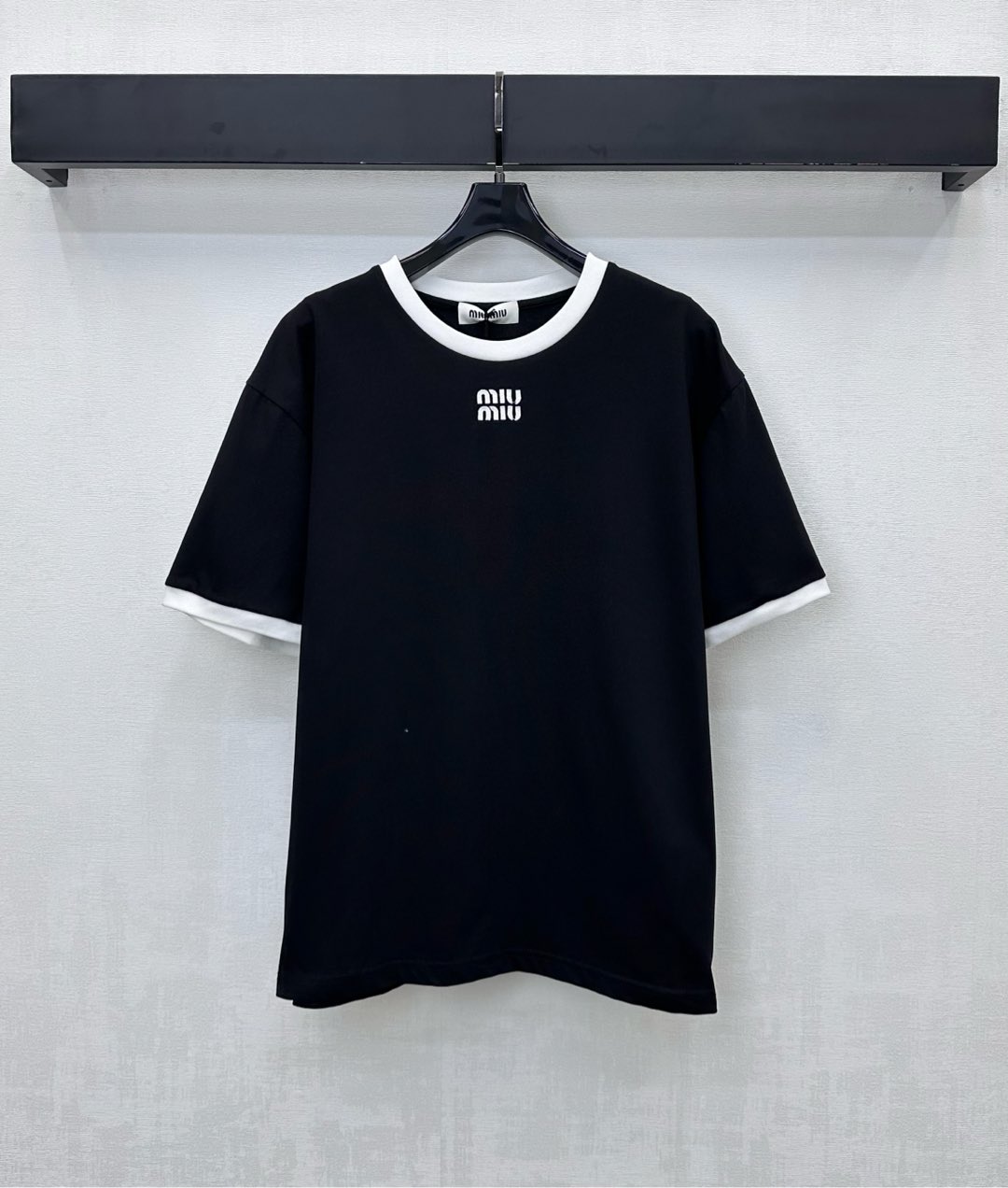 NO:576897,Miumi*2025 new products are on the shelves. Round neck with contrasting logo and customized YB imported raw cotton material. Comfortable, breathable and full of texture. Solid color bottoming with contrasting edge design on collar and cuffs to add layering to the look. Iconic letter logo decoration on the chest. Highlights the brand's development of tonal surface accessories. Regular short-sleeved T-shirt tailoring to create a personalized style. It is stylish when worn alone. High version 2 colors, miumiu, T-shirt, tees, t-shirt, alexander  wang19860909Miumi*2025新品上架圆领撞色徽标定制YB进口原生全棉材质 舒适透气 质感十足 通体素色打底配合领口袖口撞色包边设计 增添造型层次感 胸前点缀标志性字母徽标装饰 彰显品牌调性面辅料开发 常规短袖T恤剪裁 打造个性风格 单穿内搭出彩时髦 高版本2色,,miumiu,T-shirt,tees，t-shirt,alexander wang,Women's clothing