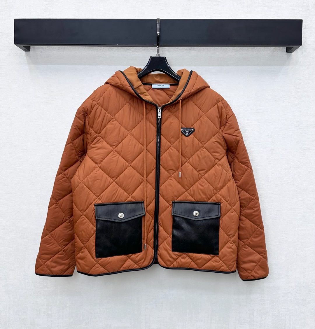 NO:589192,Prad*2025 new products are on the shelves. The hooded cotton jacket is made of imported YB nylon. The interior is filled with diamond-shaped cotton. The whole piece is light and warm. The zipper is used for adjustment and is decorated with symmetrical flap leather pockets to add layering to the look. It is warm and does not appear bloated, making it more wearable. The iconic triangle logo design is embellished on the chest with diamond texture to highlight the brand's tone. Development of surface accessories. Cutting of the hooded zipper jacket. All-over black binding.  Casual fashionable outerwear high version, prada, jackets & coats, hats, alexander wang19860909Prad*2025新品上架连帽棉服外套定制YB进口尼龙材质 内里菱格衔棉填充 整件轻盈保暖 沿用开襟拉链调节配合对称翻盖皮革口袋装饰 增添造型层次感 暖和不显臃肿穿搭性更强 菱格纹理胸前点缀标志性三角徽标设计 彰显品牌调性 面辅料开发 连帽拉链外套版型剪裁 通体黑色包边加持 随意外搭时髦洋气 高版本,,prada,jackets & coats,hats,alexander wang,Women's clothing