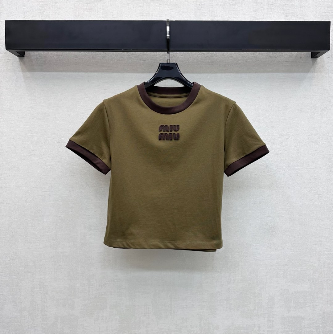NO:697279,Miumi*2026 new products are on the shelves, customized with contrasting letter logo and YB imported raw twill cotton material. Full texture, comfortable and breathable. The collar and cuffs are processed with brown hemming. The overall body creates a visual collision. Combined with the short version design, it adds a sense of layering. The iconic embroidered letter logo elements are embellished on the chest to highlight the brand tone. Development of surface accessories. Round neck short T-shirt cut. Casual and relaxed for daily commuting. Very comfortable to wear alone or as a layer.  High version,,miumiu,tees,t-shirt,19860909Miumi*2026新品上架撞色字母徽标定制YB进口原生斜纹全棉材质 质感十足 舒适透气 领边与袖口采用棕色包边处理 整体大身产生视觉效果的碰撞 配合短款版型设计 增添造型层次感 胸前点缀标志性刺绣字母徽标元素 彰显品牌调性 面辅料开发 圆领短款T恤剪裁 日常通勤休闲松弛 单穿或内搭都很舒服 高版本,,miumiu,tees，t-shirt,,Women's clothing