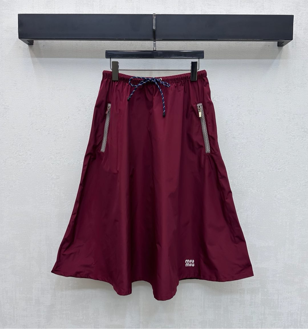 NO:697236,Miumi*2026 new products are on the shelves. The assault drawstring skirt is made of YB imported assault nylon material. Breathable and comfortable, full of texture. The whole body is plain and decorated with symmetrical zipper pockets. The drawstring adjusts the elasticity to fit the body, adding layering to the shape. The iconic letter logo decoration on the side highlights the brand tone. The development of surface accessories. The drawstring umbrella-shaped skirt is cut. It can be paired with the vest jacket of the same series. The cable drawstring highlights the details to enhance the fashion of outdoor activities.  Look stylish in any outfit. High version, miumiu, skirts, jackets & coats,19860909Miumi*2026新品上架冲锋抽绳半裙定制YB进口冲锋尼龙材质 透气舒适 质感十足 大身通体素色配合对称拉链口袋装饰 抽绳调节松紧贴合身型 增添造型层次感 边侧点缀标志性字母徽标装饰 彰显品牌调性 面辅料开发 抽绳伞状半裙剪裁 可搭配同系列马甲外套 绞花抽绳点亮呼应细节 提升户外活动穿搭的时尚度 随意穿搭都出彩时髦  高版本,,miumiu,skirts,jackets & coats,,Women's clothing