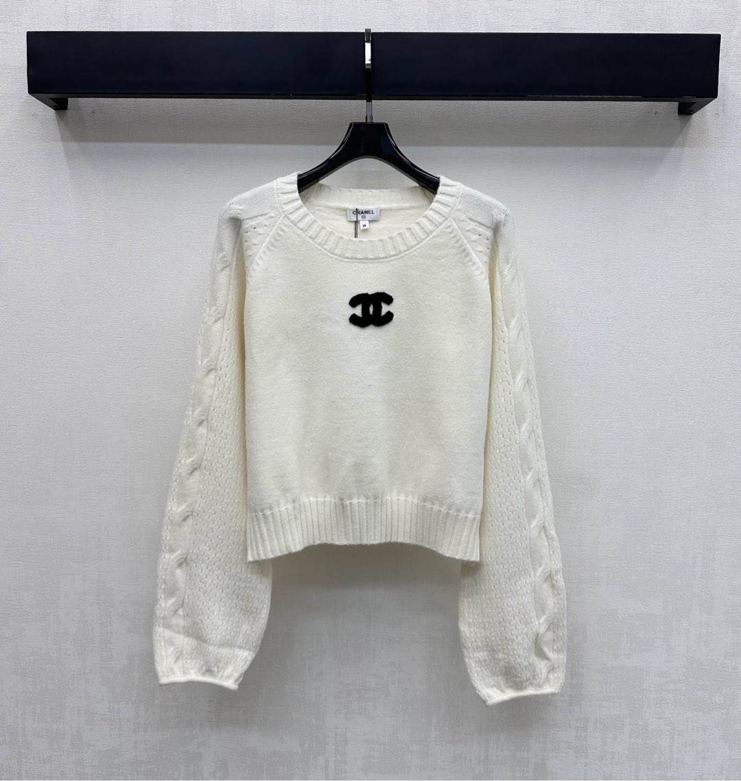 NO:708823,Chane*2026 New Arrival Round Neck Logo Knitted Top Customized YB Imported Wool Blended Knitted Material High Quality, Comfortable and Soft The sleeves on both sides are designed with hollow rhombus and cable work. The collar and hem are processed with threaded hemming details to add layering to the look. The iconic double C letter logo is embellished with black contrasting colors on the chest to highlight the brand tone. Development of surface accessories. The pullover knitted sweater is cut loose with lantern sleeves to hide the flesh and is casual.  You can easily achieve the French lazy and exquisite style by wearing it alone or as an inner layer. High version 36 38 40,,chanel,sweaters,19860909Chane*2026新品上架圆领徽标针织上衣定制YB进口羊毛混纺针织材质 质感上乘 舒适柔软 两侧袖沿用镂空菱格与绞花工艺设计 领边与衣摆都采用螺纹包边细节处理 增添造型层次感 胸前点缀黑色撞色标志性双C字母徽标 彰显品牌调性 面辅料开发 套头针织毛衣剪裁宽松灯笼袖藏肉又随性 单穿内搭皆可轻松拿捏法式慵懒的精致格调  高版本36 38 40,,chanel,sweaters,,Women's clothing