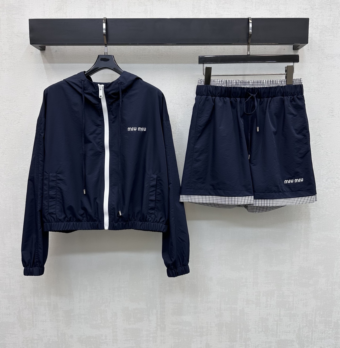 NO:748379,Miumi*2026 new arrivals hooded jacket plaid shorts suit customized with YB imported assault nylon material. Breathable and comfortable, full of texture. Elastic drawstrings are used to fit the body shape. Contrast color zipper adjustment and waist and leg pants splicing plaid design add layering to the look. The short version is more lightweight and flexible. The chest is embellished with iconic letter embroidered logo decoration. The details echo up and down to highlight the brand tone. Development of surface accessories. Short hooded zipper jacket with high waist drawstring shorts tailoring.  Improve the fashion of outdoor activities. Wear casually and stylishly. High version,,miumiu,shorts,jackets & coats,hats,19860909Miumi*2026新品上架连帽外套格纹短裤套装定制YB进口冲锋尼龙材质 透气舒适 质感十足 沿用抽绳松紧贴合身型 配合撞色拉链调节与腰头腿裤拼接格纹设计 增添造型层次感 短款版型更轻便灵活 胸前点缀标志性字母刺绣徽标装饰 细节上下呼应 彰显品牌调性 面辅料开发 连帽短款拉链外套高腰抽绳短裤剪裁 提升户外活动穿搭的时尚度 随意穿搭出彩时髦  高版本,,miumiu,shorts,jackets & coats,hats,,Women's clothing