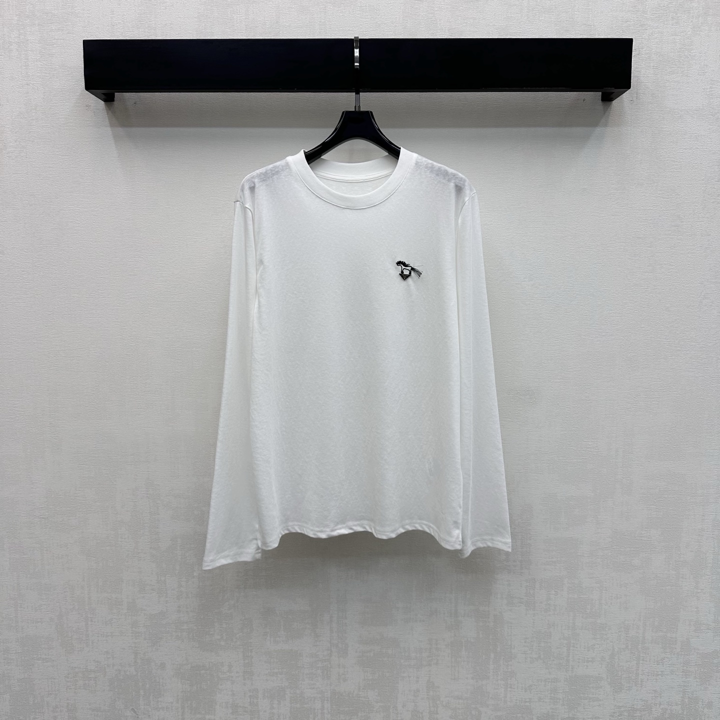 NO:751094,Prad*2026 new products are on the shelves. Round neck logo long-sleeved custom-made YB imported virgin cotton material. High-quality texture, comfortable and breathable. The neckline is processed with threaded hemming details. It is tailored with a loose fit to add layering to the shape. The chest is decorated with an embroidered pony logo and the iconic triangle logo to highlight the brand tone. Surface accessories development. Round neck long-sleeved T-shirt tailoring. Stylish when worn alone. High version, prada, tees, t-shirt,19860909Prad*2026新品上架圆领徽标长袖定制YB进口原生全棉材质 质感上乘 舒适透气 领口采用螺纹包边细节处理 配合宽松版型裁剪 增添造型层次感 胸口饰以刺绣小马徽标配合标志性三角标点缀装饰 彰显品牌调性 面辅料开发 圆领长袖T恤剪裁 单穿内搭出彩时髦  高版本,,prada,tees，t-shirt,,Women's clothing