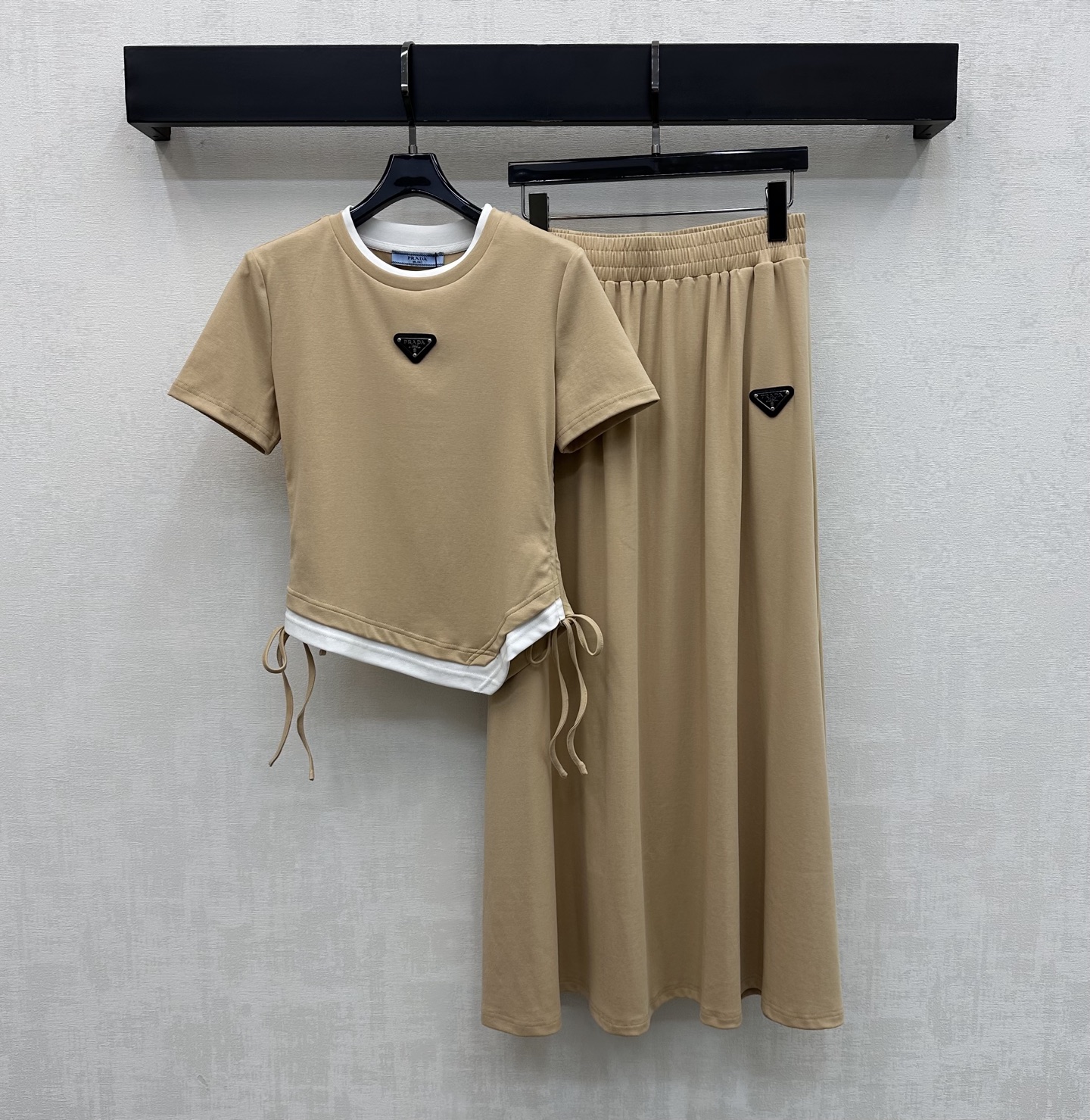 NO:752271,Prad*2026 new arrivals, fake two-piece T-shirt and skirt suit, customized with YB imported twill cotton material, high quality, comfortable and breathable. The collar and hem are processed with fake two-piece contrasting details. It is matched with a symmetrical drawstring adjustment design to add layering to the look. The chest is embellished with the iconic triangle logo decoration, echoing elements from top to bottom to highlight the brand tone. Development of surface accessories. Slim-fitting short T-shirt, pleated long skirt cut. Simple and relaxed daily commuting wear.  High version 3 colors, prada, skirts, tees, t-shirt,19860909Prad*2026新品上架假两件T恤半裙套装定制YB进口斜纹棉材质 质感上乘 舒适透气 领口衣摆采用拼接撞色假两件细节处理 配合对称抽绳调节设计 增添造型层次感 胸前点缀标志性三角徽标装饰 上下呼应元素 彰显品牌调性 面辅料开发 修身短款T恤压褶长半裙剪裁 日常通勤穿搭简约松弛  高版本3色,,prada,skirts,tees，t-shirt,,Women's clothing