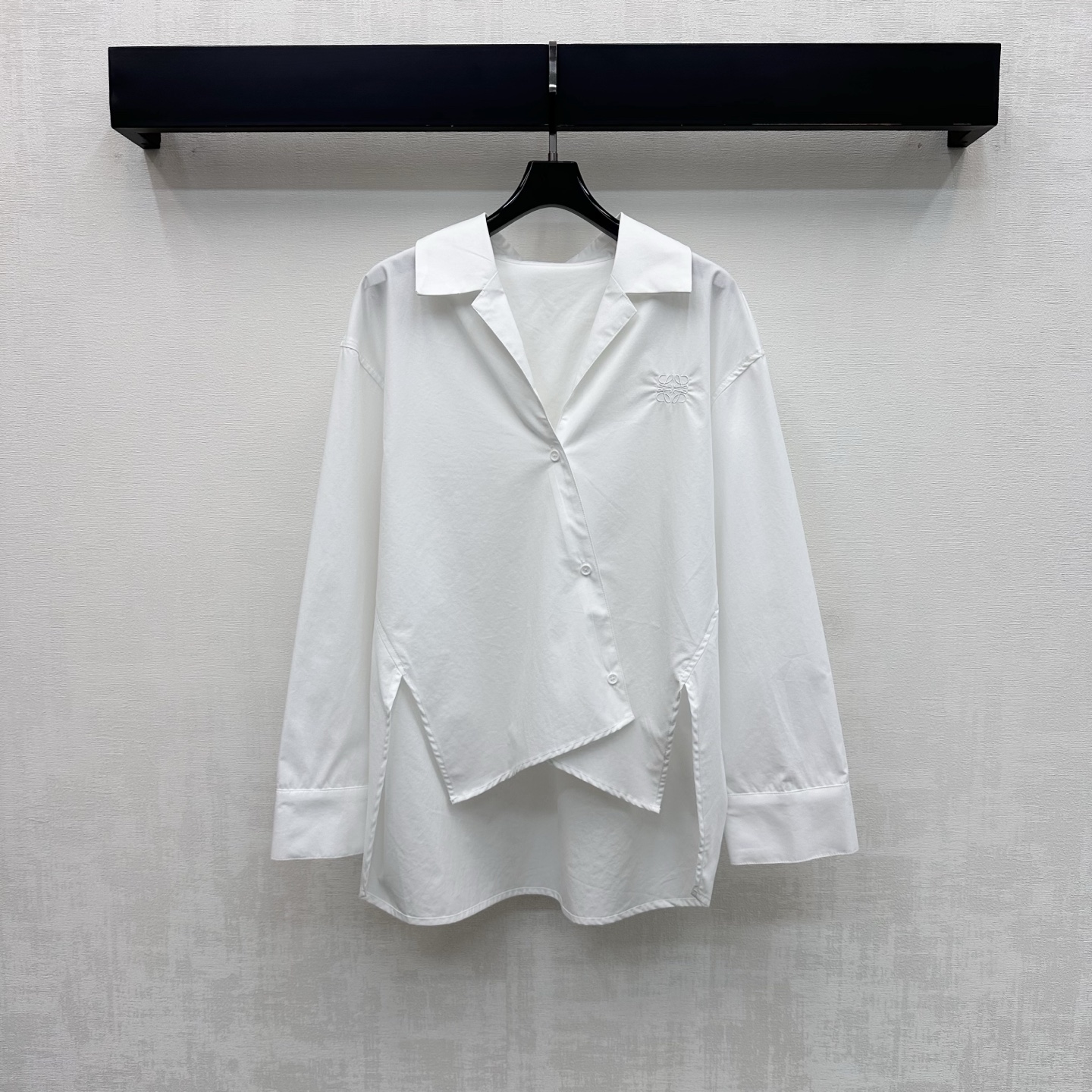 NO:792108,Loew*2026 New Arrival Irregular Lapel Shirt Customized YB Imported Twill Cotton Material Soft and Skin-Friendly, Comfortable and Wrinkle-Free. Use oblique button adjustment to match the short front and long back irregular hem design to add layering to the look. The chest is embellished with the iconic embroidered logo decoration to highlight the brand tone. The back is spliced with contrasting fabrics of the same color to create an elite and high-intellectual feel. Development of surface accessories. Silhouette lapel shirt tailoring. Casual matching for daily commuting and appointments to wear in high fashion.  High version 2 colors,,loewe,shirts,19860909Loew*2026新品上架不规则翻领衬衣定制YB进口斜纹棉材质 柔软亲肤 舒适不易皱 沿用斜襟纽扣调节配合前短后长不规则下摆设计 增添造型层次感 胸口点缀标志性刺绣徽标装饰 彰显品牌调性 后背拼接同色系不同面料撞色处理 打造精英高智感 面辅料开发 廓形翻领衬衫版型剪裁 日常通勤约会随意搭配穿搭高级时髦 高版本2色,,loewe,shirts,,Women's clothing