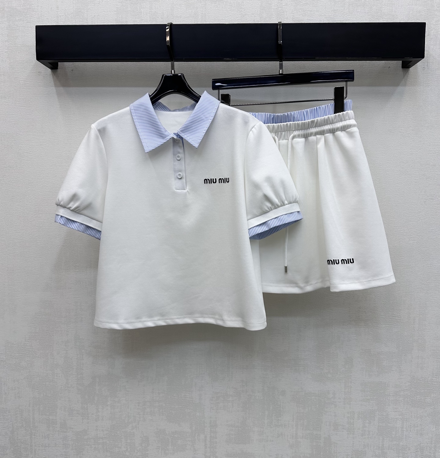 NO:794140,Miumi*2026 new products are on the shelves. The spliced plaid top and skirt suit is made of YB imported cotton. It is breathable and comfortable. The collar and cuffs are made of plaid shirt fabric splicing design. It echoes the waist details to make it more coordinated. It adds layering to the look. The iconic letter embroidered logo on the chest echoes the same design of the skirt. Highlights the brand tone. Development of surface accessories. Lapel short-sleeved top with pleated skirt cut. Complete set to reduce age and youthful college style.  High version 2 colors,,miumiu,skirts,shirts,T-shirt,19860909Miumi*2026新品上架拼接格纹上衣半裙套装定制YB进口全棉材质 透气舒适 领边袖口沿用格纹衬衫面料拼接设计 与腰头细节相呼应更显协调 增添造型层次感 胸前点缀标志性字母刺绣徽标呼应裙摆同样设计 彰显品牌调性 面辅料开发 翻领短袖上衣压褶半裙剪裁 成套穿搭减龄青春学院风 高版本2色,,miumiu,skirts,shirts,T-shirt,,Women's clothing