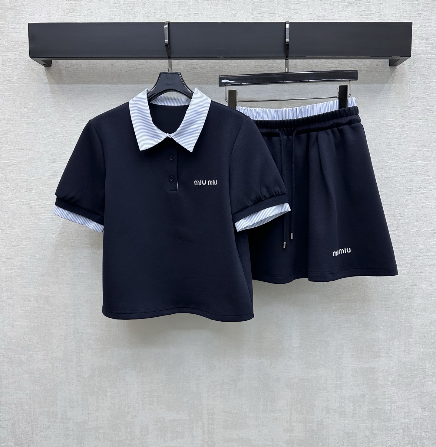 NO:794143,Miumi*2026 new products are on the shelves. The spliced plaid top and skirt suit is made of YB imported cotton. It is breathable and comfortable. The collar and cuffs are made of plaid shirt fabric splicing design. It echoes the waist details to make it more coordinated. It adds layering to the look. The iconic letter embroidered logo on the chest echoes the same design of the skirt. Highlights the brand tone. Development of surface accessories. Lapel short-sleeved top with pleated skirt cut. Complete set to reduce age and youthful college style.  High version 2 colors,,miumiu,skirts,shirts,T-shirt,19860909Miumi*2026新品上架拼接格纹上衣半裙套装定制YB进口全棉材质 透气舒适 领边袖口沿用格纹衬衫面料拼接设计 与腰头细节相呼应更显协调 增添造型层次感 胸前点缀标志性字母刺绣徽标呼应裙摆同样设计 彰显品牌调性 面辅料开发 翻领短袖上衣压褶半裙剪裁 成套穿搭减龄青春学院风 高版本2色,,miumiu,skirts,shirts,T-shirt,,Women's clothing