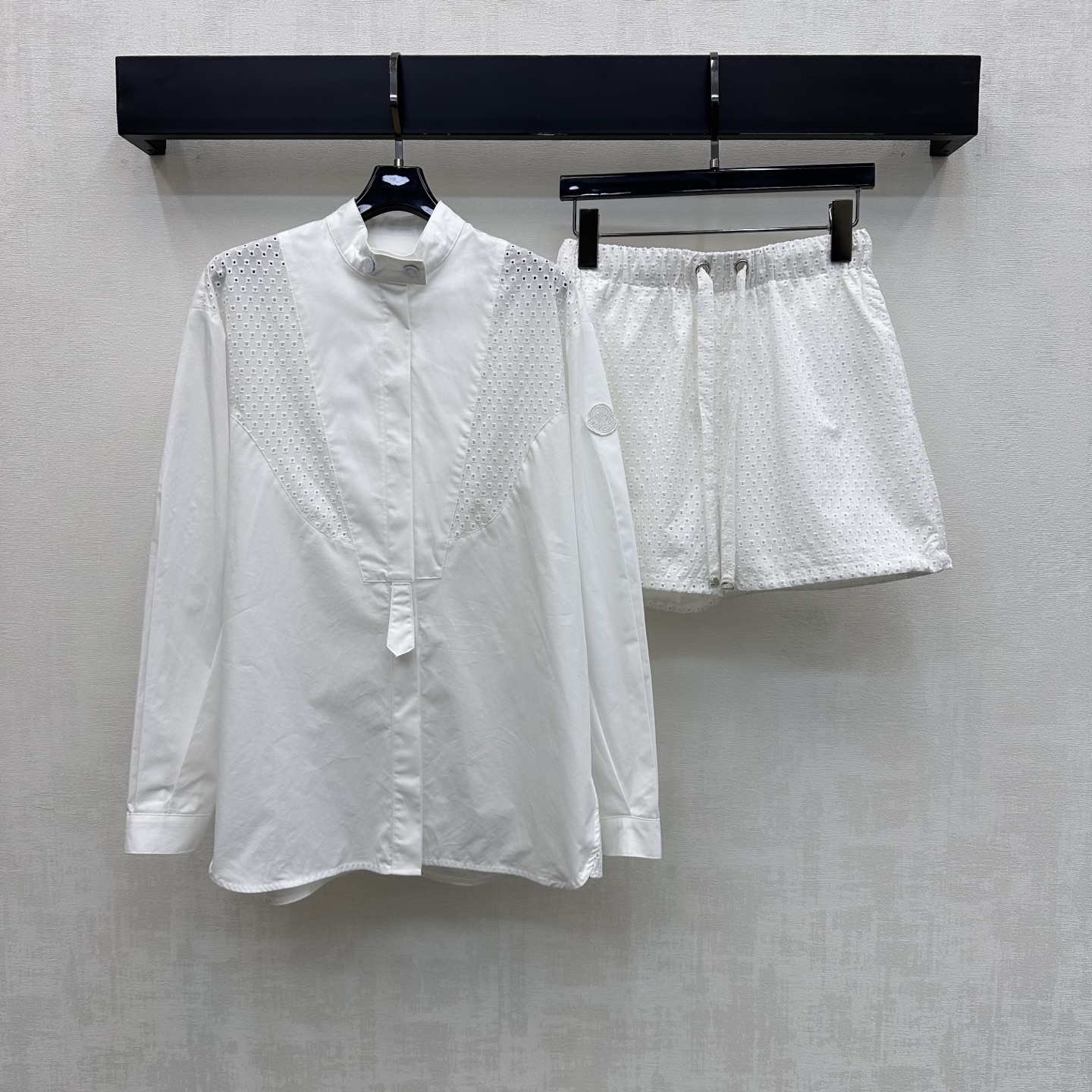 NO:805368,Moncle*2026 new arrival embroidered shirt and shorts suit customized with YB imported twill cotton material. Fine texture, crisp and stylish. Stand-up collar placket button adjustment design. Combined with splicing and hollow embroidery process to add layering to the look. The cuffs are embellished with iconic badge logo decoration and echo the back waist to highlight the brand tone. Full of French manor resort feel. Loose silhouette is fashionable and soft. Development of surface accessories. Stand-up collar long-sleeved shirt with drawstring shorts cut.  Easy to wear for commuting and vacation with a sense of style. High version, shorts, shirts,19860909Moncle*2026新品上架绣花衬衣短裤套装定制YB进口斜纹全棉材质 质感细腻 挺括有型 立领版型开襟纽扣调节设计 配合拼接镂空绣花工艺处理 增添造型层次感 袖口点缀标志性徽章标识装饰与后腰呼应 彰显品牌调性 法式庄园度假感十足 宽松廓形时尚柔美 面辅料开发 立领长袖衬衫抽绳短裤剪裁 通勤度假轻松穿搭出洋气感 高版本,,shorts,shirts,,Women's clothing