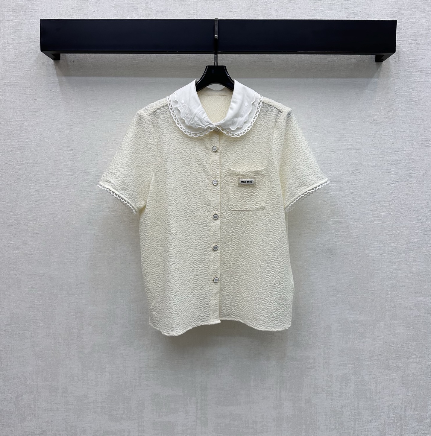 NO:825455,Miumi*2026 new arrivals doll collar short-sleeved shirt customized YB imported cotton blended material. The texture is crisp and delicate, skin-friendly and breathable. The whole body is made of water ripple texture and lace doll collar contrasting splicing design to add layering to the look. Enrich the visual effects and highlight the French sweet brand tone. The chest pocket is decorated with the iconic letter logo to highlight the brand tone. Development of surface accessories. Lapel short-sleeved shirt tailoring. Easily wear a girly atmosphere for daily commuting and dating.  High version 2 colors,,miumiu,shirts,T-shirt,19860909Miumi*2026新品上架娃娃领短袖衬衫定制YB进口棉纶混纺材质 质感挺括细腻 触感亲肤透气 通体采用水波纹肌理与蕾丝花边娃娃领撞色拼接设计 增添造型层次感 丰富视觉效果 彰显法式甜美品牌调性 胸前口袋点缀标志性字母徽标装饰 彰显品牌调性 面辅料开发 翻领短袖衬衣剪裁 日常通勤约会轻松穿出少女感氛围感   高版本2色,,miumiu,shirts,T-shirt,,Women's clothing