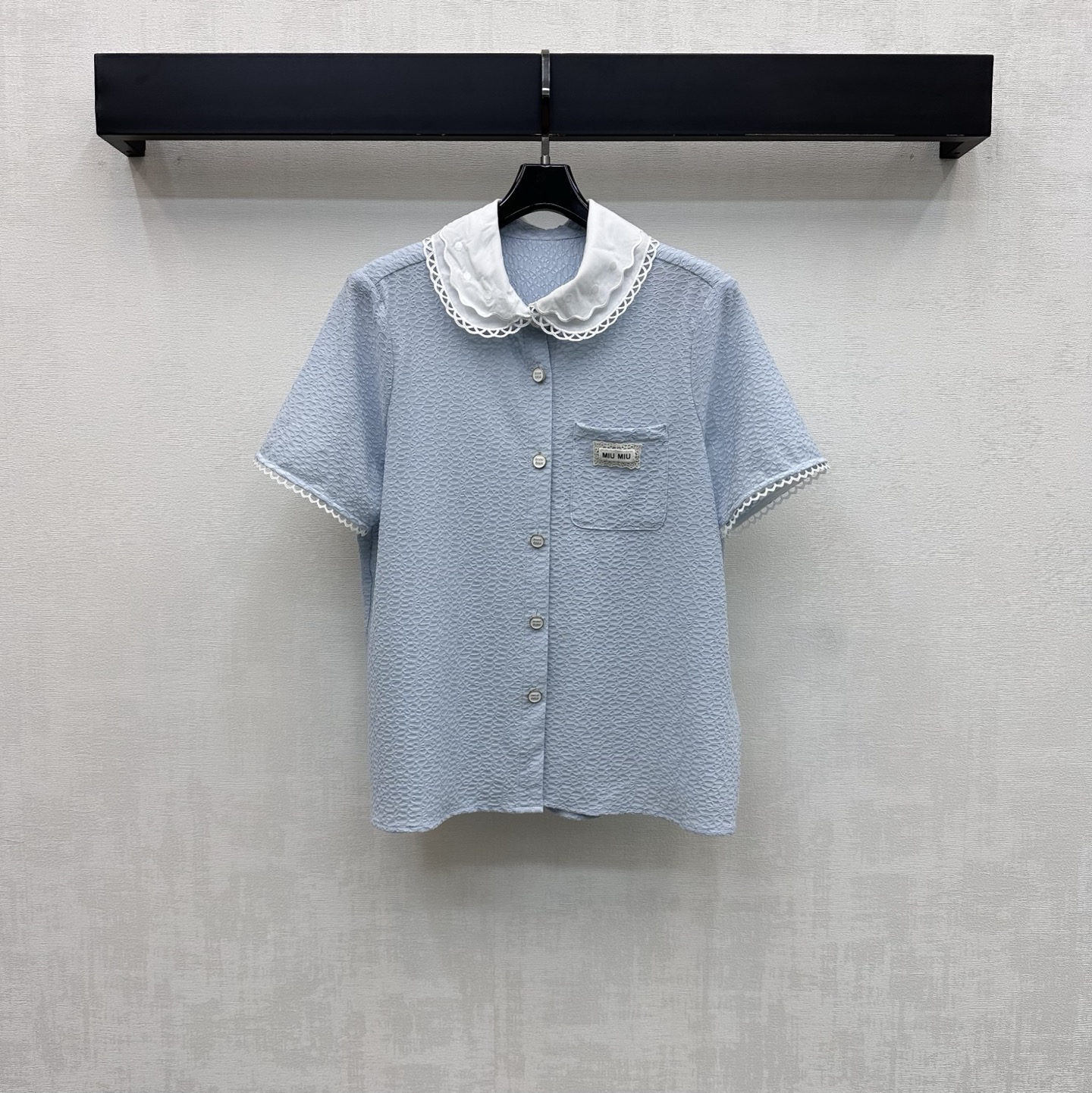 NO:825478,Miumi*2026 new arrivals doll collar short-sleeved shirt customized YB imported cotton blended material. The texture is crisp and delicate, skin-friendly and breathable. The whole body is made of water ripple texture and lace doll collar contrasting splicing design to add layering to the look. Enrich the visual effects and highlight the French sweet brand tone. The chest pocket is decorated with the iconic letter logo to highlight the brand tone. Development of surface accessories. Lapel short-sleeved shirt tailoring. Easily wear a girly atmosphere for daily commuting and dating.  High version 2 colors,,miumiu,shirts,T-shirt,19860909Miumi*2026新品上架娃娃领短袖衬衫定制YB进口棉纶混纺材质 质感挺括细腻 触感亲肤透气 通体采用水波纹肌理与蕾丝花边娃娃领撞色拼接设计 增添造型层次感 丰富视觉效果 彰显法式甜美品牌调性 胸前口袋点缀标志性字母徽标装饰 彰显品牌调性 面辅料开发 翻领短袖衬衣剪裁 日常通勤约会轻松穿出少女感氛围感   高版本2色,,miumiu,shirts,T-shirt,,Women's clothing