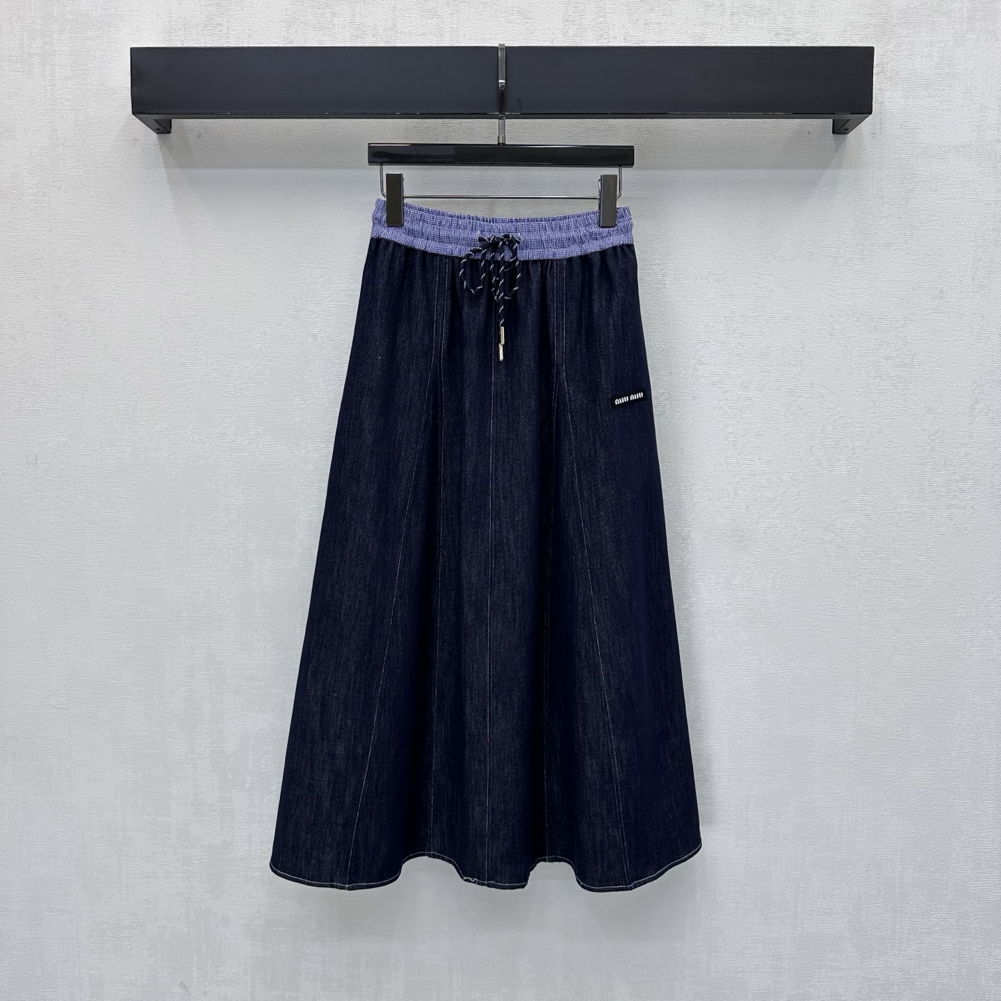 NO:831557,Miumi*2026 new products are on the shelves. The spliced denim skirt is made of YB imported twill cotton denim material. It is very wide, comfortable and stylish. The whole body is washed with dark primary colors to create a retro texture. The side pockets are decorated with iconic letter logos to highlight the brand tone. The contrasting design of the waistband of the plaid shirt fabric is used. It is cut with pleated skirts. It effectively modifies the straight leg line and adds a sense of layering when worn without restraint. Surface accessories development. High-waisted A-line skirt cutting.  Casual and stylish outfit for daily commuting. High version, miumiu, skirts,19860909Miumi*2026新品上架 拼接牛仔半裙定制YB进口斜纹棉丹宁牛仔材质 挺阔舒适有型 通体采用深色原色水洗工艺处理 打造复古质感 侧口袋点缀标志性字母徽标装饰 彰显品牌调性 沿用格纹衬衣面料腰头拼接撞色设计 配合压褶裙摆裁剪处理 有效修饰直腿线条穿着无束缚感增添造型层次感 面辅料开发 高腰抽绳 A字半裙剪裁 日常通勤随意搭配穿搭时髦高级 高版本,,miumiu,skirts,,Women's clothing