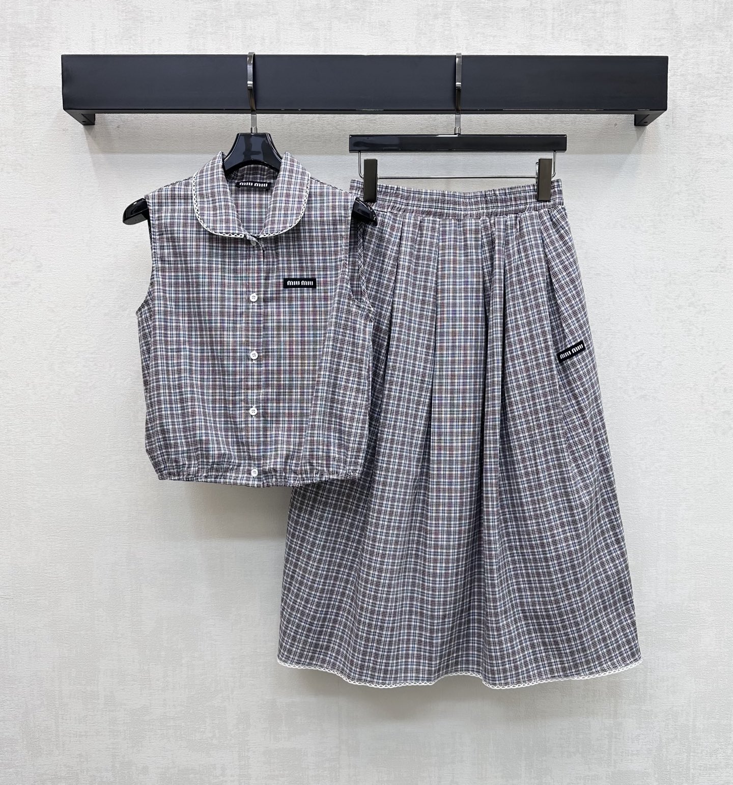 NO:845228,Miumi*2026 new arrivals plaid vest skirt suit customized YB imported cotton and linen blended fabric. Light and breathable texture with a slight texture. Classic blue and gray fine plaid retro art has age-reducing attributes. The collar skirt is decorated with lace design to add layering to the look. The iconic letter logo decoration is embellished on the chest, waist and crotch to highlight the brand's tone. The short version easily creates a high waistline and visually lengthens the leg proportions. The A-line mid-length skirt is highly inclusive.  Covers the fleshy thighs and is very friendly to pear-shaped figures. Development of fabric accessories. Lapel sleeveless shirts and pleated skirts. Easily create a British preppy style when worn as a set. High version,,miumiu,skirts,shirts,19860909Miumi*2026新品上架格纹背心半裙套装定制YB进口棉麻混纺面料 质地轻盈透气 带有微微肌理感 经典蓝灰细格纹复古文艺 自带减龄属性 领边裙摆饰以蕾丝花边设计 增添造型层次感 胸口腰胯处均点缀标志性字母徽标装饰 彰显品牌调性 短款版型轻松打造高腰线 视觉上拉长腿部比例 A字中长裙摆包容性强 遮住大腿肉肉 对梨形身材非常友好 面辅料开发 翻领无袖衬衫压褶半裙 成套穿搭轻松打造英伦学院风   高版本,,miumiu,skirts,shirts,,Women's clothing