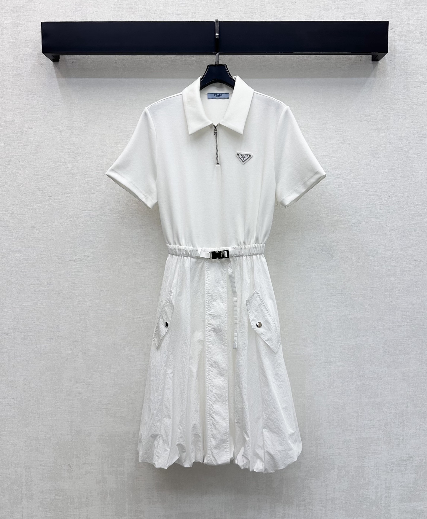 NO:844549,Prad*2026 new arrivals Flower bud belt dress is made of YB imported twill cotton nylon material. Comfortable, breathable and stylish. Decorated with the iconic letter triangle logo on the chest to highlight the brand's tone. Half-open zipper adjustment with buckle webbing waist design adds a sense of layering to the look. It outlines the waistline and elongates the proportion of the lower body, making it visually taller. The fluffy flower bud silhouette at the hem is individual and eye-catching. Full score for age reduction effect. Development of surface accessories  Lapel short-sleeved dress tailoring. Pair it with Martin boots or dad shoes. Easily look like a street trendy person. High version 2 colors, prada, boots, skirts, T-shirt,19860909Prad*2026新品上架花苞腰带连衣裙定制YB进口斜纹棉尼龙材质 舒适透气有型 胸前点缀标志性字母三角徽标装饰 彰显品牌调性 半开襟拉链调节配合卡扣织带收腰设计 增添造型层次感 勾勒腰线拉长下半身比例 视觉上更显高挑 下摆蓬蓬花苞廓形个性吸睛 减龄效果满分 面辅料开发 翻领短袖连衣裙剪裁 搭配马丁靴还是老爹鞋 轻松打造街头潮人 高版本2色,,prada,boots,skirts,T-shirt,,Women's clothing