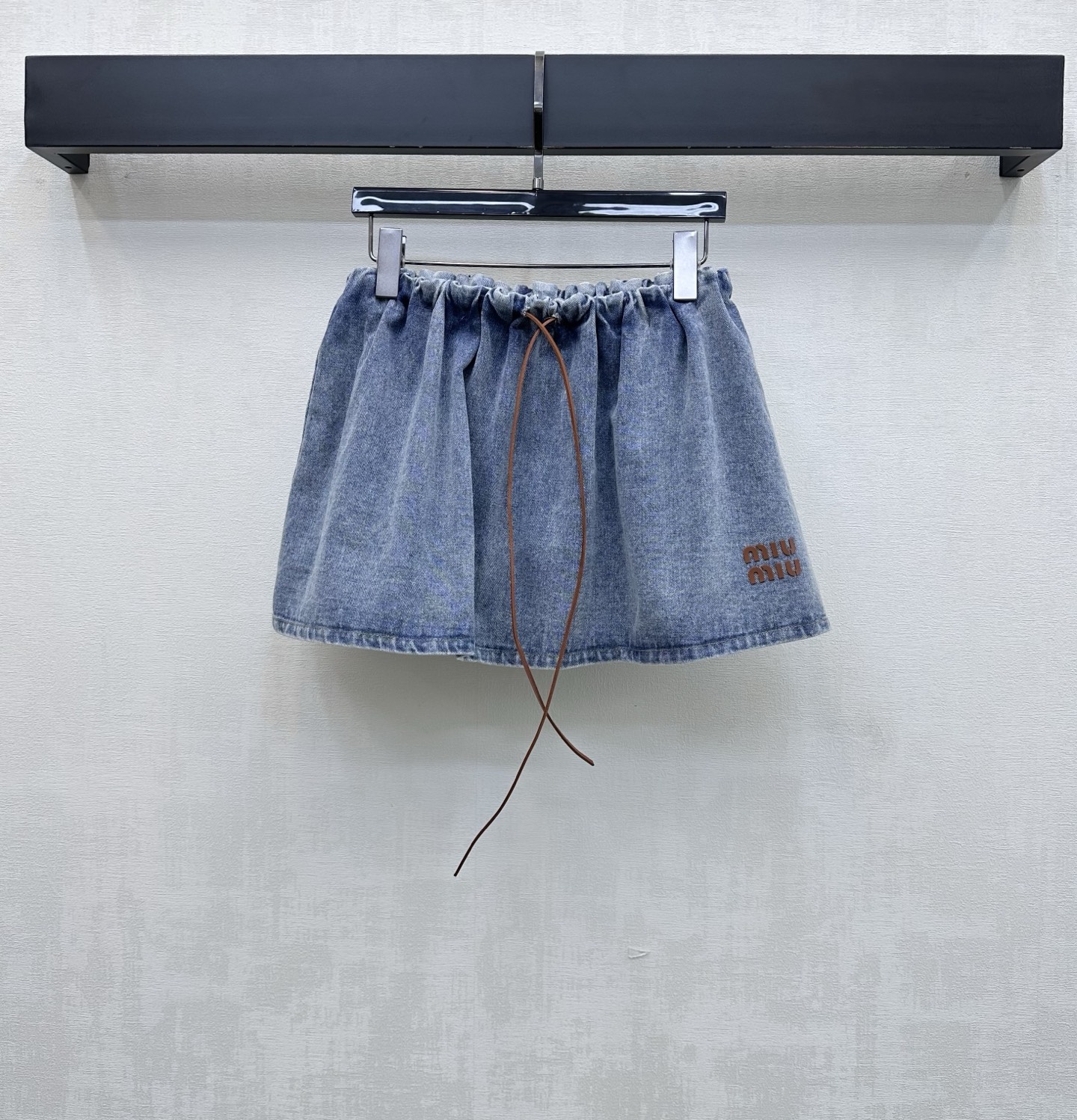 NO:844493,Miumi*2026 New Products Leather Cord Denim Skirt Customized YB imported twill cotton denim fabric. The texture is crisp and stylish. It feels dry and comfortable. Classic washed retro blue with a distressed white effect. It is visually more layered. The sides of the skirt are decorated with iconic leather label letters to highlight the brand tone. Add a sweet and cool atmosphere. Eye-catching and fashionable. Brown leather cord drawstring elastic waist adjustment design  With the A-line hem, it perfectly covers the wide crotch and thighs, showing a slimming effect. The short high-waisted version visually makes you taller. Easily create the golden ratio of 30 to 70 points. Add layering to the look. It is casual and natural, showing the street trend. The development of surface accessories. The high-waisted pleated short skirt can be paired with the same series of jackets. It is easy to create a Korean sweet and cool style when worn as a set. High version,,miumiu,skirts,jackets & coats,gold,19860909Miumi*2026新品上架皮绳牛仔半裙定制YB进口斜纹全棉牛仔面料 质地挺括有型 触感干爽舒适 经典水洗复古蓝 自带做旧磨白效果 视觉上更具层次感 裙摆侧边点缀标志性皮标字母装饰 彰显品牌调性 增加甜酷气息 吸睛又时髦 棕色皮绳抽绳松紧腰调节设计 配合下摆A字版型完美遮住胯宽大腿遮肉显瘦效果一流 短款高腰版型视觉上更显高挑 轻松打造三七分黄金比例 增添造型层次感 随性自然尽显街头潮流感 面辅料开发 高腰压褶短裙剪裁 可搭配同系列外套 成套搭配穿搭轻松打造韩系甜酷风  高版本,,miumiu,skirts,jackets & coats,gold,,Women's clothing