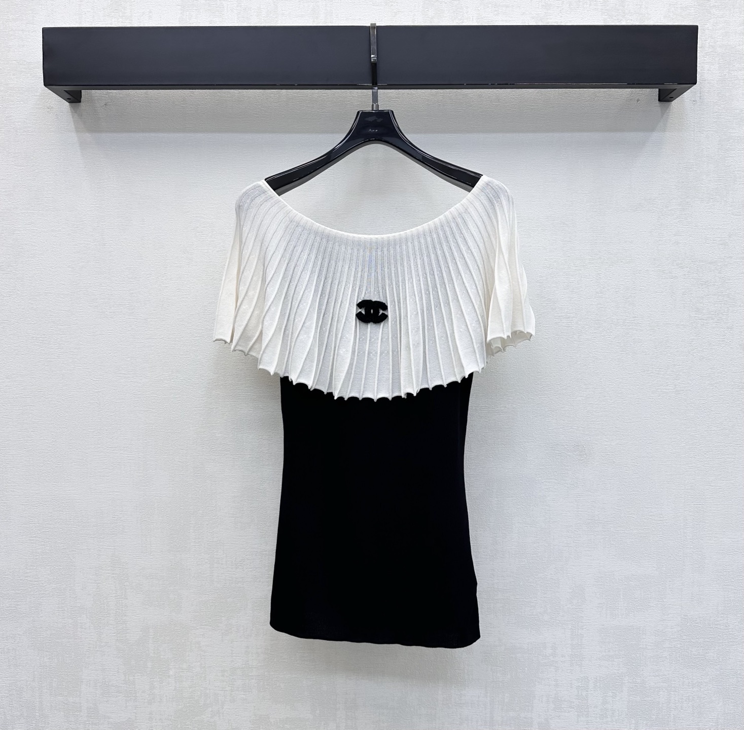 NO:858363,Chane*2026 new products are on the shelves. Black and white contrasting stitching knitted custom YB imported blended fabric. The texture is light and breathable. It feels soft and skin-friendly. The classic black and white contrasting colors are clean and neat. The upper body has a cool and high-end atmosphere. The upper part adopts exquisite vertical pleated texture splicing design to break the monotony and increase the visual layer and three-dimensionality. The iconic double C is decorated in the center of the chest. The letter logo is decorated in a low-key way to highlight the quality and brand style. The loose one-line neckline covers the flesh and makes you look slimmer. It accommodates all body types.  Development of surface accessories. Cutting of one-shoulder tops. Wear casually with skirts and trousers. Easily create French elegance. High version 2 colors 36 38 40,,chanel,skirts,19860909Chane*2026新品上架黑白撞色拼接针织定制YB进口混纺面料 质地轻盈透气 触感软糯亲肤 经典的黑白撞色干净利落 上身自带清冷高级氛围 上半部分采用精致竖向褶皱肌理拼接设计 打破单调增加视觉层次与立体感 胸口居中点缀标志性双C 字母徽标装饰 低调彰显品质与品牌格调 宽松一字领版型遮肉显瘦 包容各种身材 面辅料开发 一字肩上衣版型剪裁 随意搭配裙裤装穿搭 轻松打造法式优雅风  高版本2色36 38 40,,chanel,skirts,,Women's clothing