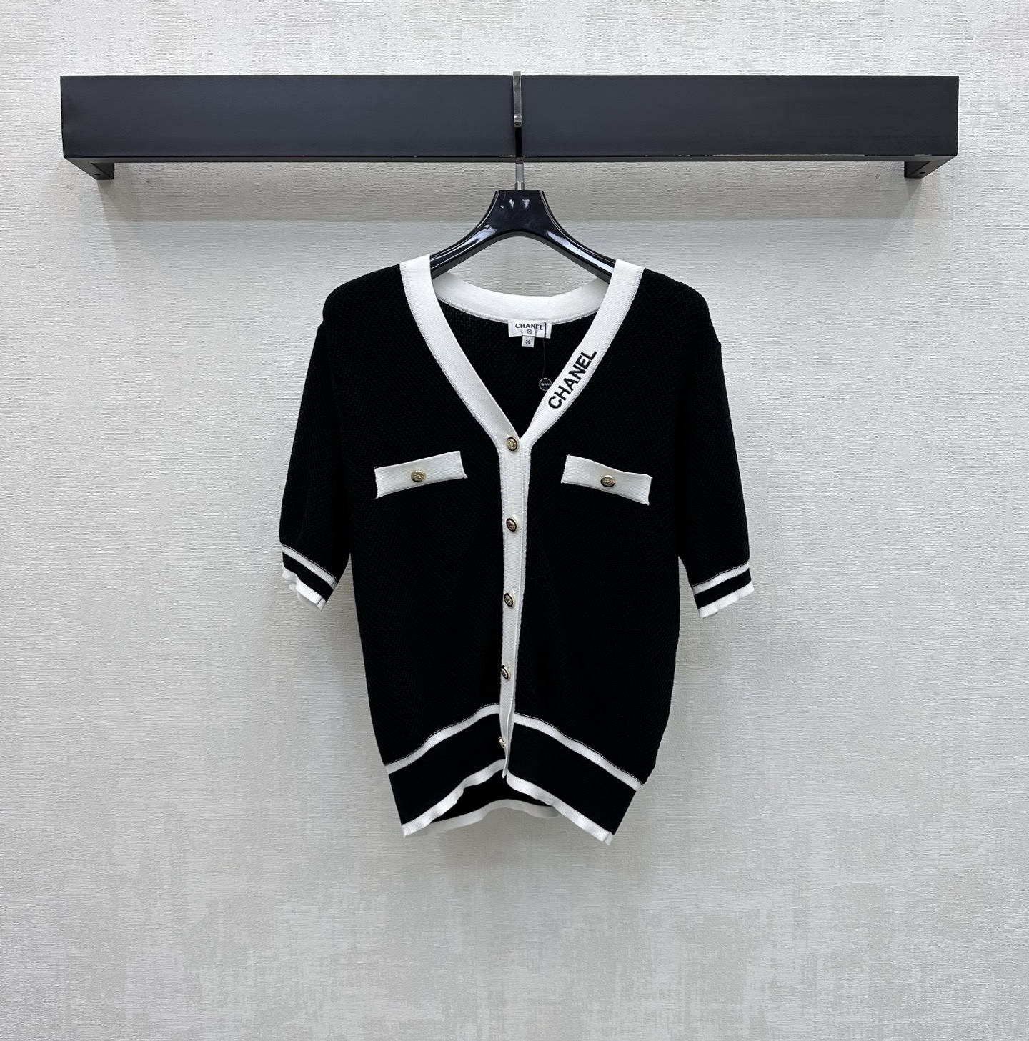 NO:866650,Chane*2026 new products are on the shelves. Contrast color V-neck short-sleeved knitted cardigan. Customized YB imported ice silk blended knitted fabric. Light and breathable texture. Soft and skin-friendly. With a delicate micro-permeable texture. Visually more slimming effect. Classic black and white contrast design adds layering to the look. The upper body has a cool and elegant celebrity atmosphere. The side of the collar is embellished with iconic letter embroidery logo decoration to highlight the brand tone. Development of surface accessories.  V-neck short-sleeved cardigan cut. Wear it alone or layered with it, you can easily create a minimalist and high-end style. High version 2 colors 36 38 40,,chanel,T-shirt,19860909Chane*2026新品上架撞色V领短袖针织开衫 定制YB进口冰丝混纺针织面料 质地轻盈透气 触感软糯亲肤 带有细腻的微透肌理感 视觉上更具显瘦效果 经典的黑白撞色设计 增添造型层次感 上身自带清冷优雅的名媛氛围 领边侧面点缀标志性字母刺绣徽标装饰 彰显品牌调性 面辅料开发 V领短袖开衫剪裁 单穿还是内搭都能轻松打造极简高级风  高版本2色36 38 40,,chanel,T-shirt,,Women's clothing