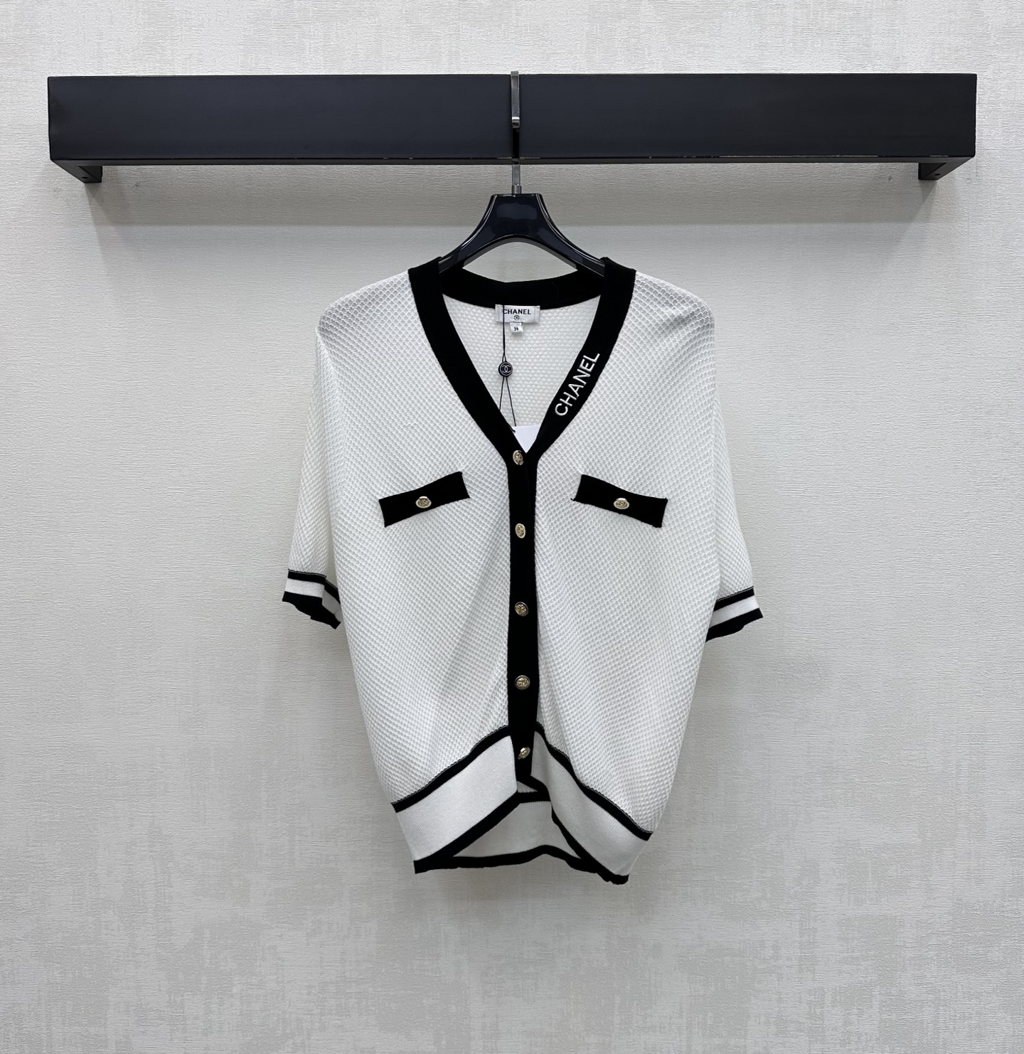 NO:866665,Chane*2026 new products are on the shelves. Contrast color V-neck short-sleeved knitted cardigan. Customized YB imported ice silk blended knitted fabric. Light and breathable texture. Soft and skin-friendly. With a delicate micro-permeable texture. Visually more slimming effect. Classic black and white contrast design adds layering to the look. The upper body has a cool and elegant celebrity atmosphere. The side of the collar is embellished with iconic letter embroidery logo decoration to highlight the brand tone. Development of surface accessories.  V-neck short-sleeved cardigan cut. Wear it alone or layered with it, you can easily create a minimalist and high-end style. High version 2 colors 36 38 40,,chanel,T-shirt,19860909Chane*2026新品上架撞色V领短袖针织开衫 定制YB进口冰丝混纺针织面料 质地轻盈透气 触感软糯亲肤 带有细腻的微透肌理感 视觉上更具显瘦效果 经典的黑白撞色设计 增添造型层次感 上身自带清冷优雅的名媛氛围 领边侧面点缀标志性字母刺绣徽标装饰 彰显品牌调性 面辅料开发 V领短袖开衫剪裁 单穿还是内搭都能轻松打造极简高级风  高版本2色36 38 40,,chanel,T-shirt,,Women's clothing