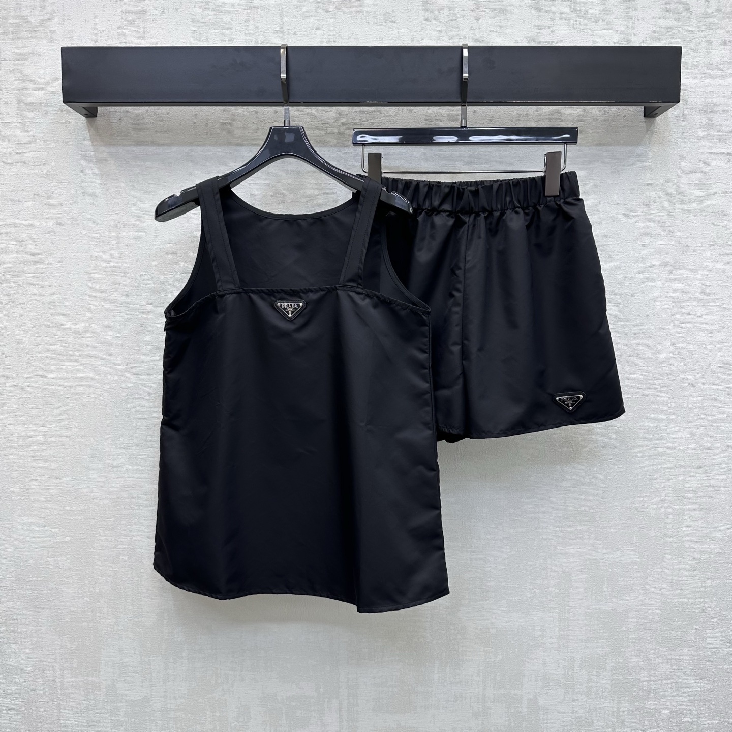 NO:876970,Prad*2026 new arrival nylon logo vest shorts suit customized YB imported environmentally friendly regenerated nylon material. Glossy, comfortable and stylish. The iconic letters are embellished in the center of the chest. The metal triangle logo decoration echoes the same details on the legs to highlight the brand tone. The printed letter details can highlight the sense of individuality and high-end. With the generous collar and shoulder strap cutting design, it adds a sense of layering to the look. The loose version modifies the waist shape and is more tolerant to the body. Development of surface accessories. Flat vest elastic waist shorts suit tailoring  Trendy and fashionable outfits for commuting and dating, high version, prada, shorts,19860909Prad*2026新品上架尼龙徽标背心短裤套装定制YB进口环保再生尼龙材质 光泽舒适有型 胸前居中点缀标志性字母金属三角徽标装饰 呼应腿侧同样细节 彰显品牌调性 印刻字母细节更能突出个性高级感 配合大方领肩带裁剪设计 增添造型层次感 宽松版型修饰腰身体型对身材包容度更高 面辅料开发 平口背心松紧腰短裤套装剪裁 通勤约会成套穿搭潮流时髦 高版本,,prada,shorts,,Women's clothing