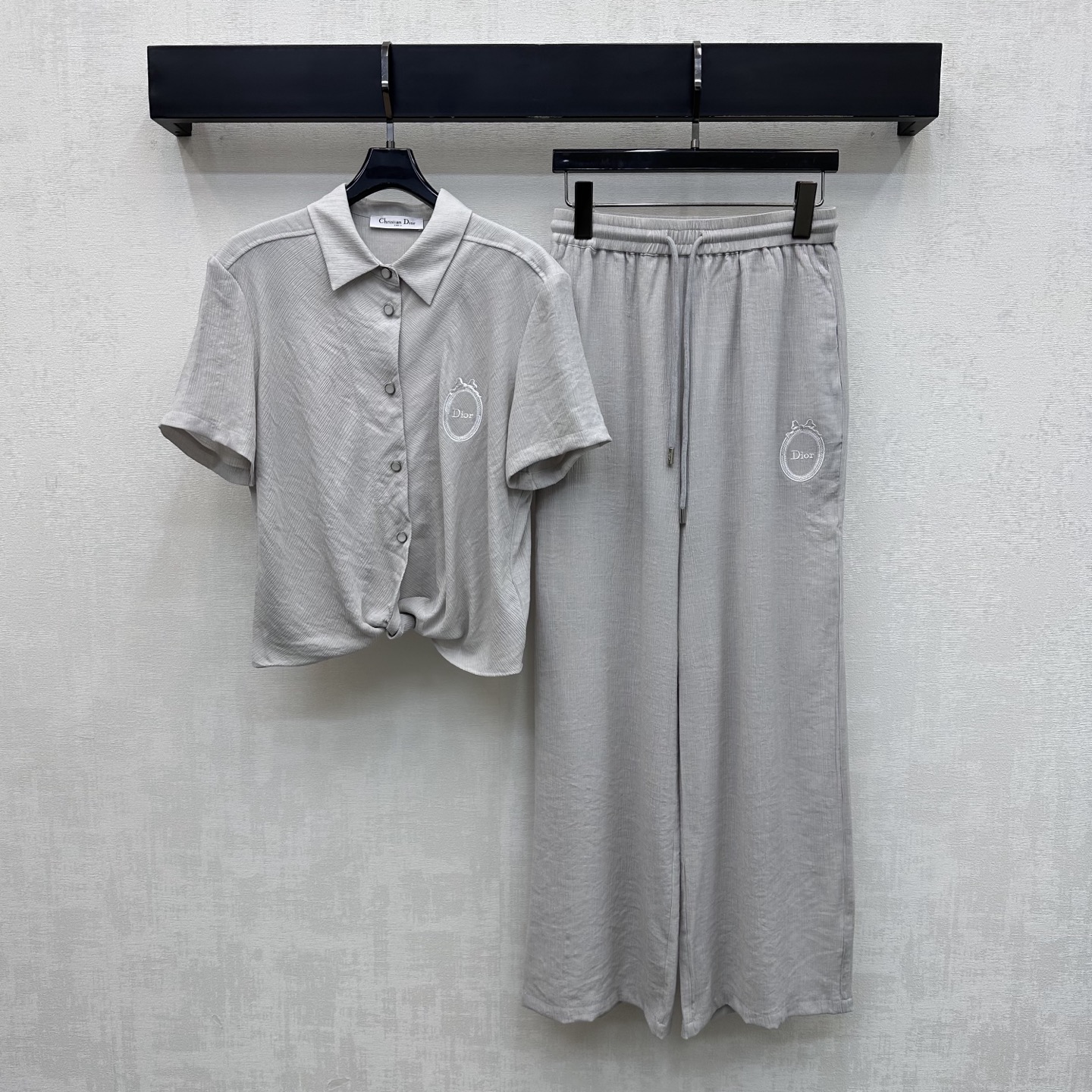 NO:878443,Dio*2026 new arrivals. Knotted shirt and trousers suit made of custom YB imported twill material. The chest is decorated with the iconic letter embroidery logo and oval frame decoration to highlight the brand tone. The hem adopts an irregular twist waist design to add layering to the look. Surface accessories development. Lapel short-sleeved shirt with drawstring straight trousers suit from the same series. The overall tailoring is neat. Easily create a variety of styles such as casual commuting and vacation. High version, dior, shirts, T-shirt,19860909Dio*2026新品上架扭结衬衫长裤套装定制YB进口斜纹绸材质 胸前饰以标志性字母刺绣徽标与椭圆边框装饰 彰显品牌调性 下摆采用不规则扭结收腰设计 增添造型层次感 面辅料开发 翻领短袖衬衫搭配同系列抽绳直筒长裤套装 整体剪裁利落 轻松打造休闲通勤度假等多种穿搭风格  高版本,,dior,shirts,T-shirt,,Women's clothing