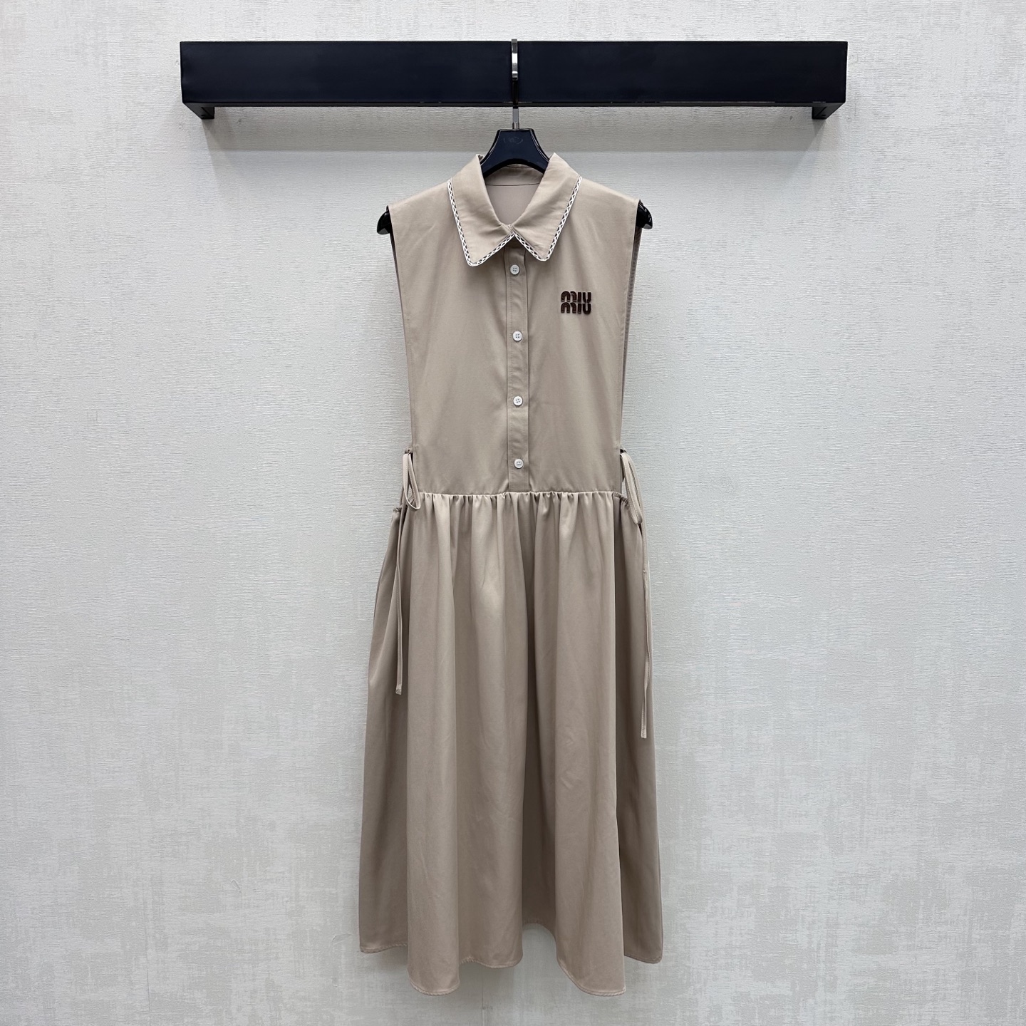 NO:878983,Miumi*2026 new products are on the shelves. The lapel waistless dress is made of YB imported cotton material. It is soft and comfortable. The collar is lace spliced ​​with a half-open button adjustment and waistband details to add layering to the look. The chest is embellished with the iconic letter leather label to highlight the brand's tone. Presenting the exclusive and well-behaved college style of the Miumi series. Surface accessories development. Lapel vest skirt tailoring. Wear to reduce age and youth. High version 2 colors,,miumiu,skirts,19860909Miumi*2026新品上架翻领露腰连衣裙定制YB进口全棉材质 柔软舒适 领边蕾丝花边拼接设计 配合半开襟纽扣调节与露腰系带细节处理 增添造型层次感 胸前点缀标志性字母皮标装饰 彰显品牌调性 呈现缪系专属乖巧学院风格 面辅料开发 翻领背心裙剪裁 穿搭减龄青春 高版本2色,,miumiu,skirts,,Women's clothing