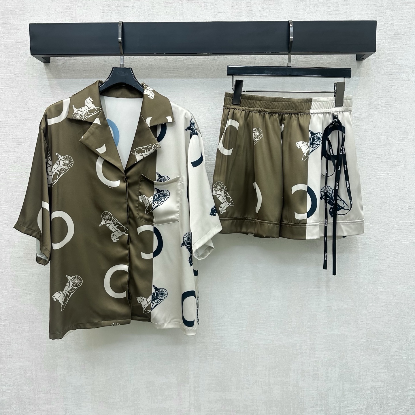 NO:884630,Celin*2026 new arrival printed shirt shorts suit customized YB imported satin material, textured and shiny, smooth and skin-friendly. It follows the iconic carriage penetration printing and C-shaped contrast stitching design. It is decorated with chest pockets to add layering to the look. The same series of letter printed streamers are embellished to highlight the brand tone. Development of surface accessories. Lapel short-sleeved shirts and elastic waist shorts are cut. The coordinated matching of the set is more refined. Relaxed outfits show nobility.  High version,,celine,shorts,T-shirt,19860909Celin*2026新品上架印花衬衣短裤套装定制YB进口缎面材质 质感光泽 顺滑亲肤 沿用标志性马车渗透印花与C字撞色拼接设计 配合胸前口袋装饰 增添造型层次感 同系列字母印花飘带点缀 彰显品牌调性 面辅料开发 翻领短袖衬衣松紧腰短裤剪裁 成套搭配协调更显精致 穿搭松弛显贵气  高版本,,celine,shorts,T-shirt,,Women's clothing