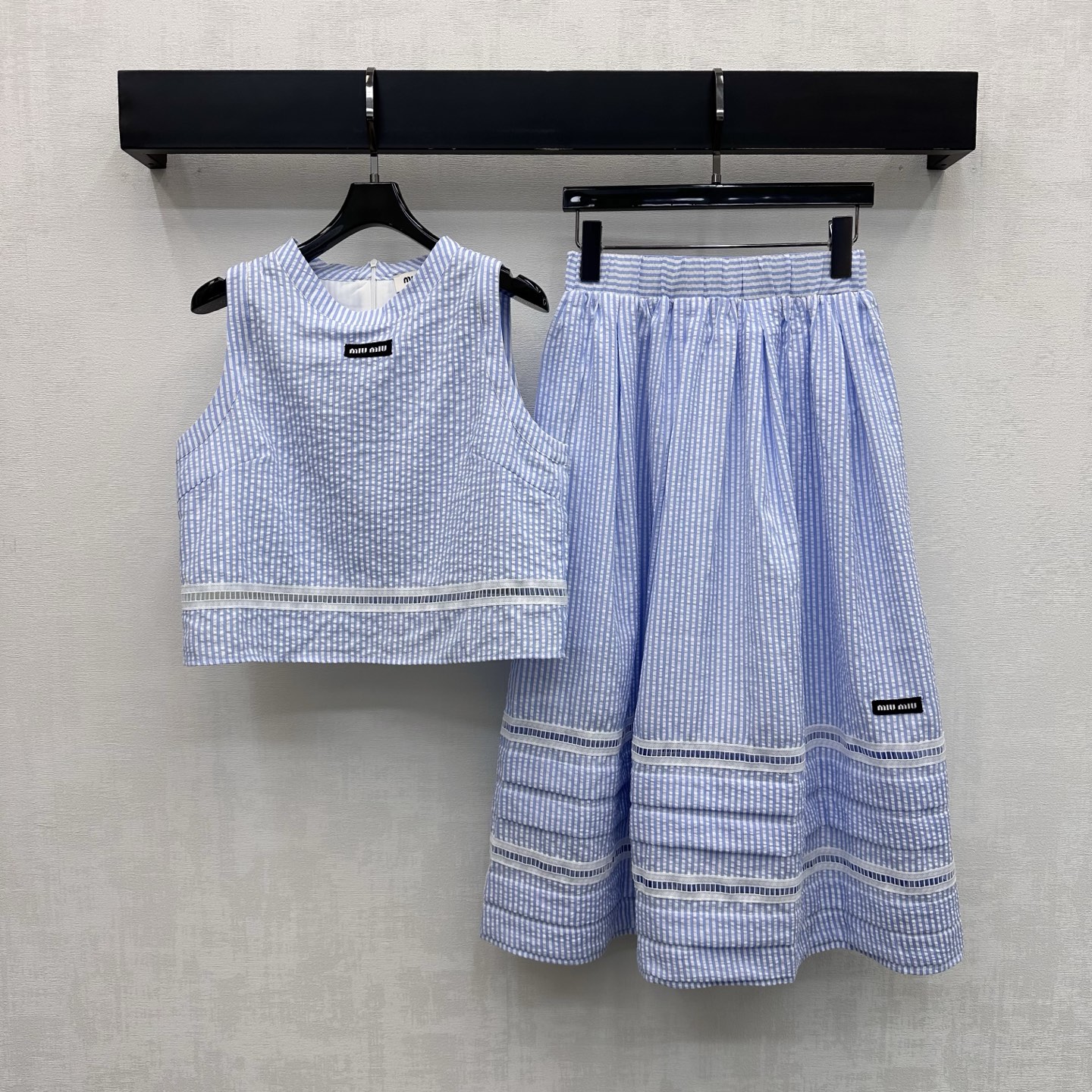 NO:889515,Miumi*2026 new arrival striped vest skirt suit customized YB imported twill cotton material, light and breathable texture, moisture-wicking, fresh blue and white stripe elements three-dimensional embossed texture throughout the body, adding layering to the look, with hollow splicing and contrasting color design, visually cooling and refreshing, reducing age, emblazoned with the iconic letter logo in the center of the chest, decorated with the same details on the side of the skirt, highlighting the brand tonality, development of surface accessories, round neck short vest, A-line umbrella skirt cut  Complete set of upper body covering the body to look slimmer. Refreshing and high-end to wear for daily dates or vacations. Comes with a sweet and ladylike temperament. High version,,miumiu,skirts,19860909Miumi*2026新品上架条纹背心半裙套装定制YB 进口斜纹棉材质 质地轻盈透气 吸湿排汗 通体采用清新蓝白条纹元素立体浮雕肌理 增添造型层次感 配合镂空拼接撞色设计 视觉降温清爽减龄 胸前居中点缀标志性字母徽标裙侧同样细节装饰 彰显品牌调性 面辅料开发 圆领短款背心A字伞裙剪裁 成套上身遮肉显瘦 日常约会还是度假穿搭清爽高级 自带甜美淑女气质 高版本,,miumiu,skirts,,Women's clothing