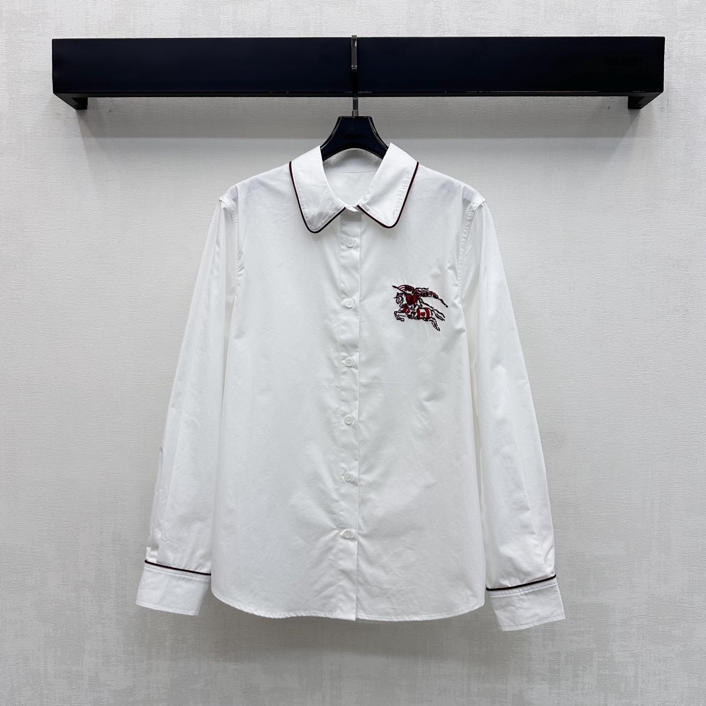 NO:924847,Bur BBR*2026 new arrival, contrasting color embroidered shirt with lapel. Customized YB imported twill cotton fabric. The texture is crisp and stylish. It feels soft and skin-friendly. It has a slight natural drape. It has a lazy and casual French atmosphere. The lapel placket button adjustment is used to add layering to the look. The collar and cuffs are designed with contrasting colors. Echoing the iconic war horse embroidered logo decoration on the chest, highlighting the brand tone. Development of surface accessories.  The lapel long-sleeved shirt is cut and can be paired with the same series of skirts. It is easy to create a high-end casual style when worn as a set. High version, burberry, skirts, shirts,19860909Bur BBR*2026新品上架翻领撞色刺绣衬衣 定制YB进口斜纹全棉面料 质地挺括有型 触感柔软亲肤 带有微微自然垂坠感 自带慵懒随性的法式氛围 沿用翻领开襟纽扣调节处理 增添造型层次感 领口与袖口采用撞色包边设计 呼应胸前标志性战马刺绣徽标装饰 彰显品牌调性 面辅料开发 翻领长袖衬衫剪裁 可搭配同系列半裙 成套穿搭轻松打造高级休闲风  高版本,,burberry,skirts,shirts,,Women's clothing