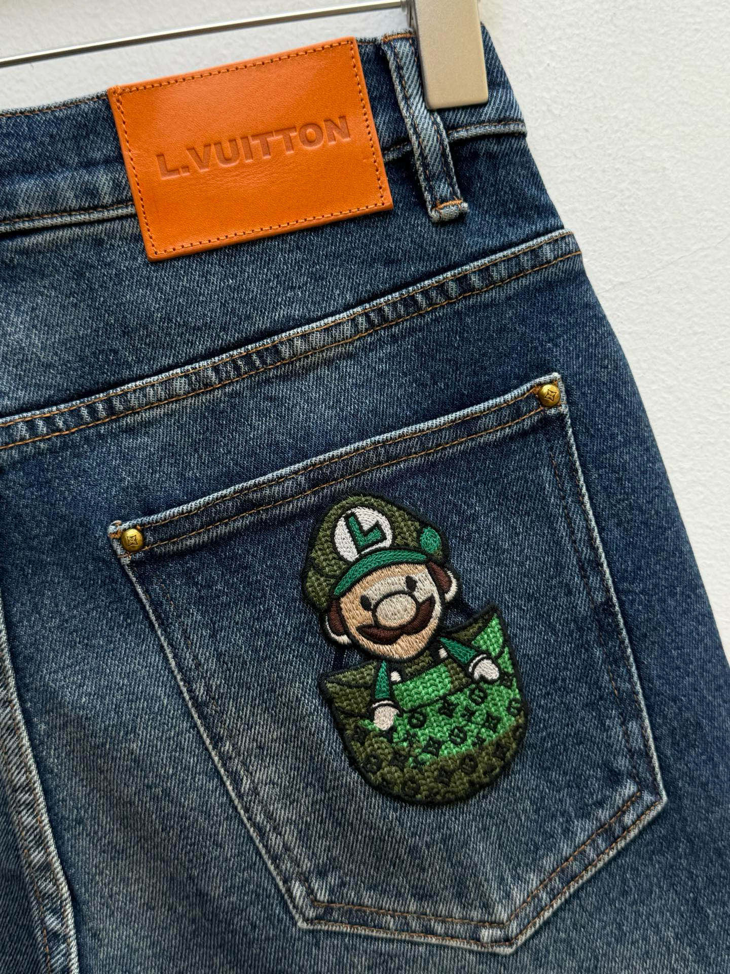 驴牌·马里奥联名毛织装饰牛仔裤、代工厂出品早秋系列这款牛仔裤采用经典的直筒微锥版型，铆钉和门襟纽扣均镌刻