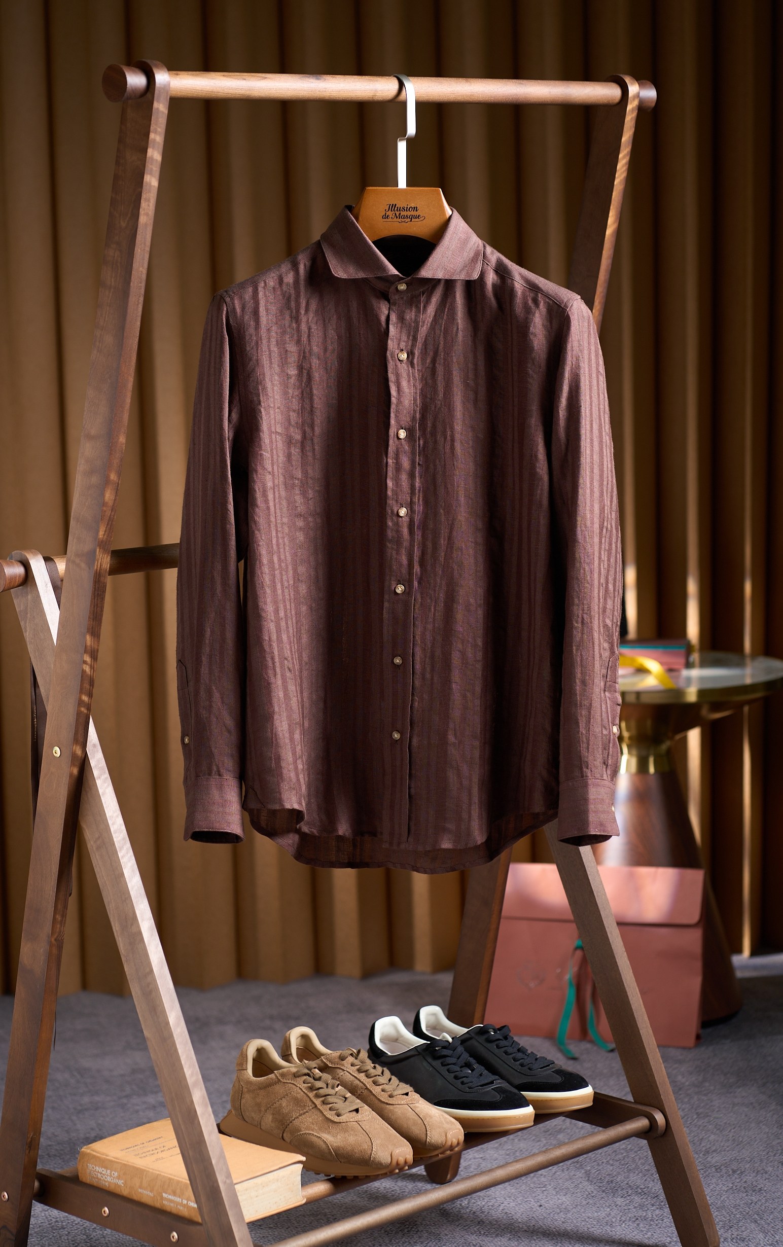 NO:775870,Vintage dark textured vertical striped linen blended cotton yarn-dyed shirt with a classic Windsor collar, hidden texture design. The collar design is an iconic Windsor collar, with a collar tip angle of 60°-80°, which naturally drape without collapse. It is suitable for ties or worn alone, and can be switched between business and leisure with one click; the collar is three-dimensionally cut to fit the neck line, highlighting the elegant temperament.  The dark pattern details are exquisite and the vertical stripes dark pattern jacquard has a low-key texture when viewed from a distance, but rich texture levels when viewed up close, breaking the monotony of solid colors and suitable for the pursuit of 'low-key and refined' dressing needs. The invisible slit design on the back enhances the freedom of movement and prevents tightness after sitting for long periods of time. It also optimizes the back line and avoids the accumulation of wrinkles at the hem of the shirt. The fabric technology is 70 linen cotton, balancing comfort and practical wear.  The golden blended 70 natural linen gives the fabric breathable and moisture-absorbing properties, and the 30 cotton fiber enhances wrinkle resistance and durability, solving the pain points of pure linen being prone to wrinkles and pure cotton being stuffy. It feels dry and non-sticky, and the body feels cooler by 3-5°C when worn in summer. The texture shows that the surface of the fabric has a natural texture, and unique 'aged' wrinkles are produced as it is worn, giving it a retro charm. After pre-shrinking, the dimensional stability after washing is improved by 80%.  The style proposition is aimed at urban men who pay attention to fabric texture and detailed design. They reject exaggeration, pursue the 'less is more' dressing philosophy, and are good at using basic styles to create a sense of luxury. Washing and care guide scientific maintenance to extend the life of fabrics 1. Washing method: gentle machine wash (water temperature ≤30℃) or hand wash, use neutral detergent to avoid chlorine bleaching; wash dark and light colors separately to prevent staining. 2.  Drying tips: Lay flat to dry or hang on the inside to avoid direct sunlight and prevent the fabric from fading; after drying, gently pull and smooth wrinkles to reduce the need for ironing. 3. Ironing recommendations: If ironing is required, choose the linen setting (150-180°C) and iron the reverse side with a damp cloth to maintain the natural texture of the fabric; focus on shaping details such as collars and cuffs. ------  Abandoning exaggeration and publicity, the delicate brushstrokes with dark textures are used to outline a unique charm on the natural linen canvas. Each texture is like a kiss left inadvertently by time, with the temperature and texture of life. Size 39-43, shirts, gold, ties,19860909复古暗纹理竖条纹亚麻混纺棉色织衬衫经典温莎领,暗藏纹理心机   领型设计标志性温莎领,领尖角度60°-80°,自然垂坠不软塌,适配领带或单穿,商务休闲一键切换；领部立体剪裁,贴合颈部线条,凸显儒雅气质.  暗纹细节细腻竖条纹暗纹提花,远观低调质感,近看纹理层次丰富,打破纯色单调,适合追求“低调精致”的穿搭需求.  后背开叉隐形开叉设计,提升活动自由度,久坐不紧绷,同时优化背部线条,避免衬衫下摆堆积褶皱. 面料工艺70亚麻棉,平衡舒适与实穿  黄金混纺70天然亚麻赋予面料透气吸湿特性,30棉纤维增强抗皱性与耐用度,解决纯亚麻易皱、纯棉闷热的痛点,触感干爽不粘身,夏季穿着体感降温3-5℃.  质感呈现面料表面带有自然肌理感,随穿着产生独特“养旧”褶皱,越穿越有复古韵味；经预缩处理,水洗后尺寸稳定性提升80.  风格主张面向注重面料质感与细节设计的都市男性,他们拒绝浮夸,追求“less is more”的穿衣哲学,擅长用基础款打造高级感. 洗护指南科学养护,延长面料寿命  1. 洗涤方式轻柔机洗（水温≤30℃）或手洗,使用中性洗涤剂,避免氯漂；深浅色分开洗涤,防止染色.  2. 晾晒技巧平铺晾干或反面悬挂,避免阳光直射,防止面料褪色；晾干后轻拉抚平褶皱,减少熨烫需求.  3. 熨烫建议若需熨烫,选择亚麻档（150-180℃）,垫湿布熨烫反面,保持面料自然肌理；领口、袖口等细节处可重点塑形. ------ 摒弃了浮夸与张扬,以暗纹理的细腻笔触,在亚麻的天然画布上勾勒出独有的韵味.每一道纹理,都像是时光不经意间留下的吻痕,带着生活的温度与质感. 码数39-43,,shirts,gold,ties,,Men's clothing