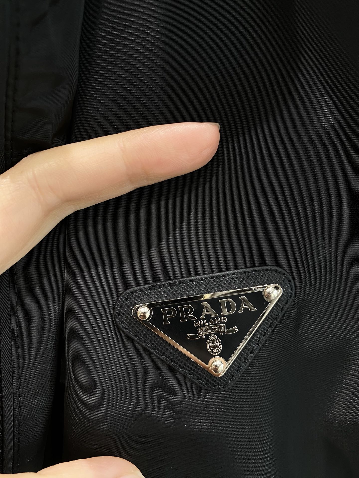 《𝙉𝙚𝙬🤍🖤 普家》
Prada夹克，时尚与实用的完美融合 经典的连帽设计，休闲感十足。胸前标志性的三角