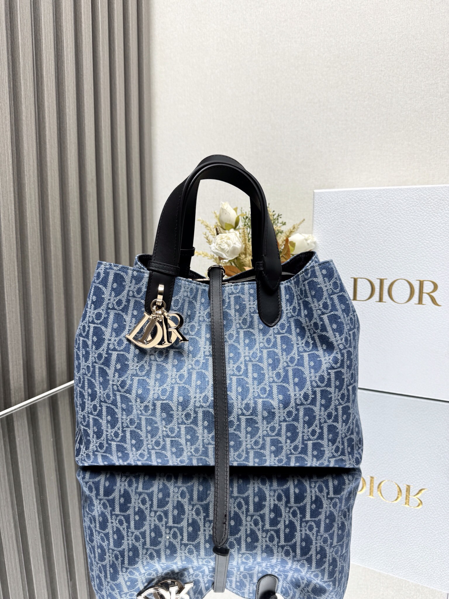 000LD中号Dior Toujours 牛仔蓝布 手袋\n这款 Dior Toujours 手袋休闲实用，别具一格。采用蓝色 Denim Dior Oblique 提花面料精心制作，以不规则的石洗效果焕新演绎 Dior 经典图案，彰显现代魅力，宽敞的内部隔层设有配套小袋，可有序收纳各种日常用品。设有纤细皮革系带开合，可安全收纳各种物品，另有 CD Lock 字母 D 旋钮式扣环，可调节两侧，提升格调。中号款式，皮革手柄带有可调节细节，可手提或肩背。\n双开合设计：纤细系带和 Christian Dior Paris 系带搭配 CD Lock 扣环\nD.I.O.R. 吊饰\n可拆卸内部小袋\n可调节皮革手柄\n\n型号：\n尺寸：. x . x  厘米（长 x 高 x 宽）\n可收纳  个钱包、 部手机、 个卡夹、太阳眼镜和唇膏