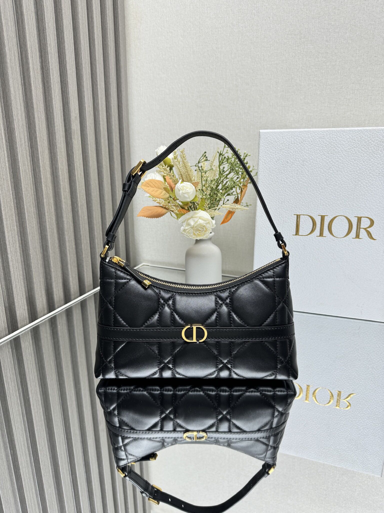 NO:771073,000460 Miss Caro Mini One-shoulder Dumpling Bag Black Sheep Leather Extra Large Cannage Pattern This mini one-shoulder dumpling bag is a new product in the 2025 early spring series. It enriches Miss with fashionable and exquisite items.  Caro collection. Crafted from black sheepskin with oversized cannage topstitching for added style, it features a decorative tone-on-tone band and a metal CD logo with an antique gold finish on the front. The zippered compartment holds a variety of daily necessities and comes with an adjustable leather shoulder strap that can be worn elegantly across the shoulder. Body: Sheepskin Lining: Sheepskin, fabric front with CD logo Zipper closure Internal compartment 1 card slot Adjustable leather strap with dust bag included Made in Italy  Size 23×13×6 Model 5232, Dior, dior, sheepskin19860909000460 Miss Caro 迷你单肩水饺包 黑色羊皮革超大藤格纹 这款迷你单肩水饺包是二零二五早春系列新品,以时尚精致的单品丰富了Miss Caro系列.采用黑色羊皮革精心制作,饰以超大藤格纹缉面线提升格调,搭配装饰性同色调饰带,正面饰以复古金色饰面金属CD标志.拉链隔层可收纳各种日常用品,搭配可调节的皮革肩带,可优雅地斜挎在肩部 主体:羊皮革 里料:羊皮革,织物正面饰以CD标志拉链开合内部隔层1个卡槽 可调节皮革肩带内含防尘袋意大利制造 尺寸23×13×6 型号5232,迪奥,dior,sheepskin,Bag
