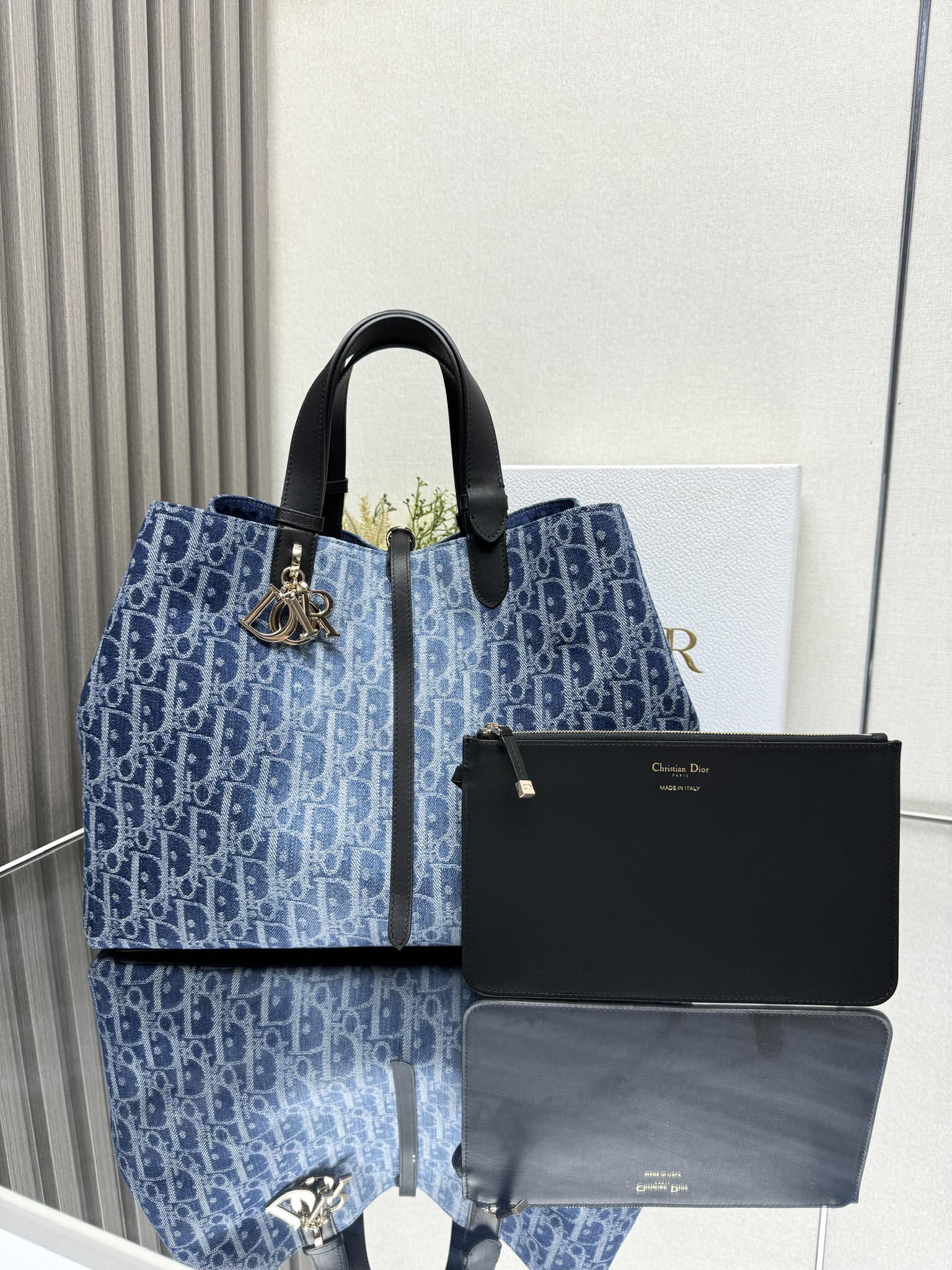 000LW大号 Dior Toujours 手袋「牛仔蓝布」\n这款 Dior Toujours 手袋休闲实用，别具一格。采用蓝色牛仔面料等材质精心制作，饰以 Graphic 藤格纹图案，以 D 效果的时尚版本全新演绎 Dior 的经典图案。宽敞的内部隔层带有配套小袋，可整齐收纳各种日常用品。设有纤细皮革系带开合，可安全收纳各种物品，另有 CD Lock 字母 D 旋钮式扣环，可调节两侧，提升格调。大号款式，皮革顶部手柄带有可调节细节，可手提或肩背。\n双开合设计：纤细系带和 Christian Dior Paris 系带搭配 CD Lock 扣环\nD.I.O.R. 吊饰\n可拆卸内部小袋\n可调节顶部皮革手柄\n\n型号：BZ\n尺寸： x  x  厘米（长 x 高 x 宽）\n空间宽敞，可收纳  部  英寸笔记本电脑、 个手拿包、 个钱包、 部手机、 个卡夹、太阳眼镜和唇膏