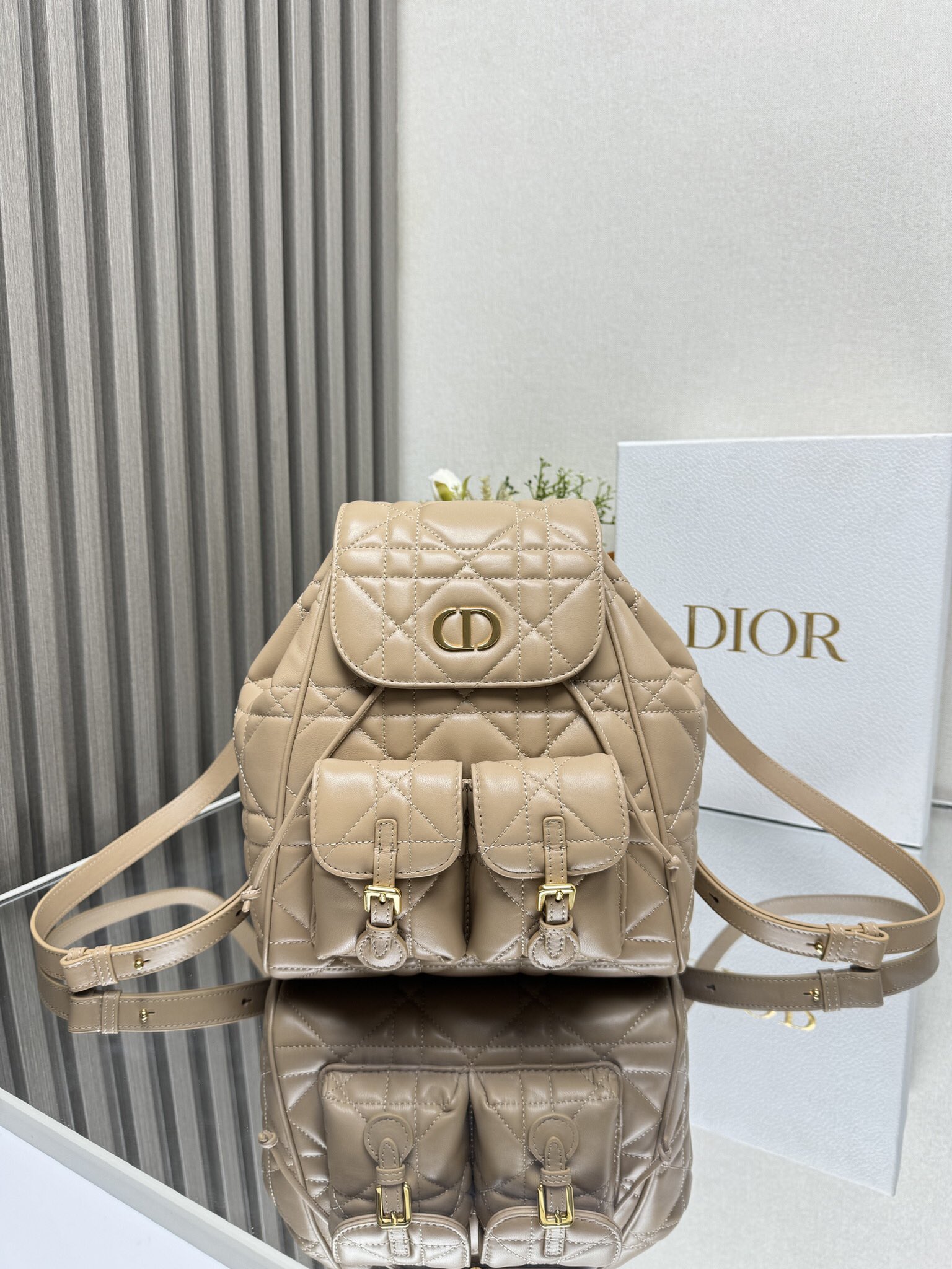 NO:771093,000720 Caro Backpack Biscuit Sheep Leather Oversized Cannage Product Information This Caro  The backpack is a new product of the 2025 early spring ready-to-wear series, showing a fashionable and elegant style. It is carefully made of black sheep leather and other materials, with oversized cannage pattern topstitching to enhance the style. The flap is decorated with a retro gold-finished metal CD logo. When opened, it reveals a spacious drawstring main compartment. Two small flap pockets can store various small daily necessities. The medium style is equipped with gold-finished handles and adjustable shoulder straps for added comfort. Main body: sheep leather, cow leather lining: cow leather  The front is decorated with CD logo flip cover and drawstring closure. Size 23×26.7×12.5cm. Model 6301, Dior, dior, backpacks, cowhide, sheepskin.19860909000720 Caro 双肩背包饼干色羊皮革超大藤格纹 产品信息 这款 Caro 双肩背包是二零二五早春成衣系列新品,彰显时尚优雅风范.采用黑色羊皮革等材质精心制作,搭配超大藤格纹缉面线提升格调,翻盖饰以复古金色饰面金属CD标志,打开后则是宽敞的抽绳主隔层,两个小号翻盖口袋可收纳各种小件日常用品.中号款式,搭配金色饰面手柄和可调节肩带,更添舒适. 主体:羊皮革,牛皮革里料:牛皮革 正面饰以CD 标志翻盖和抽绳开合 尺寸23×26.7×12.5cm 型号6301,迪奥,dior,backpacks,cowhide,sheepskin,Bag