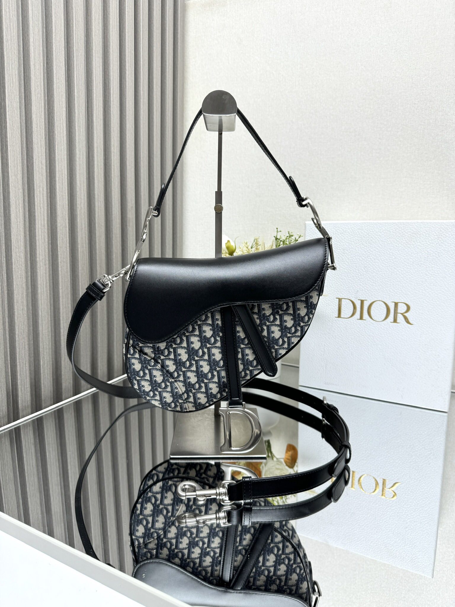 NO:209137,000530 Dior Saddle Bag (with shoulder strap) This classic saddle bag highlights the clever renewal of Maria Grazia Chiuri. It is carefully crafted from black Oblique printed fabrics, and the same-toned cowhide leather saddle flip is paired with a stirrup D-shaped sling and magnetic strap to highlight the classic design, with the sides of the handles decorated with a vintage silver-finished metal CD logo. It is paired with adjustable and removable straps for carrying, shoulder or crossbody. The straps and magnetic straps are decorated with a stirrup D-shaped sling and magnetic straps are decorated with CD logos for adjustable, removable straps Inner pockets Back side pocket Model Size 25.5 x 20 x 6.5 cm (L x H x W)  Can store 1 mobile phone, 1 card clip, sunglasses and lipstick, Dior, Dior, Cowhide19860909000530 Dior 马鞍包（附肩带） 这款经典的马鞍包突显玛丽亚·嘉茜娅·蔻丽 (Maria Grazia Chiuri) 巧妙的焕新设计.采用黑色 Oblique 印花面料等材质精心制作,同色调牛皮革马鞍翻盖搭配点缀以马镫 D 形吊饰的饰带和磁性拉带,彰显经典设计,手柄两侧饰以复古银色饰面金属 CD 标志.搭配可调节、可拆卸的细肩带,可手提、肩背或斜挎. 点缀以马镫 D 形吊饰的饰带和磁性拉带 手柄饰以 CD 标志 可调节、可拆卸的细肩带 内部口袋 后侧口袋 型号 尺寸25.5 x 20 x 6.5 厘米（长 x 高 x 宽） 可收纳 1 部手机、1 个卡夹、太阳眼镜和唇膏,迪奥,dior,dior,cowhide,Bag