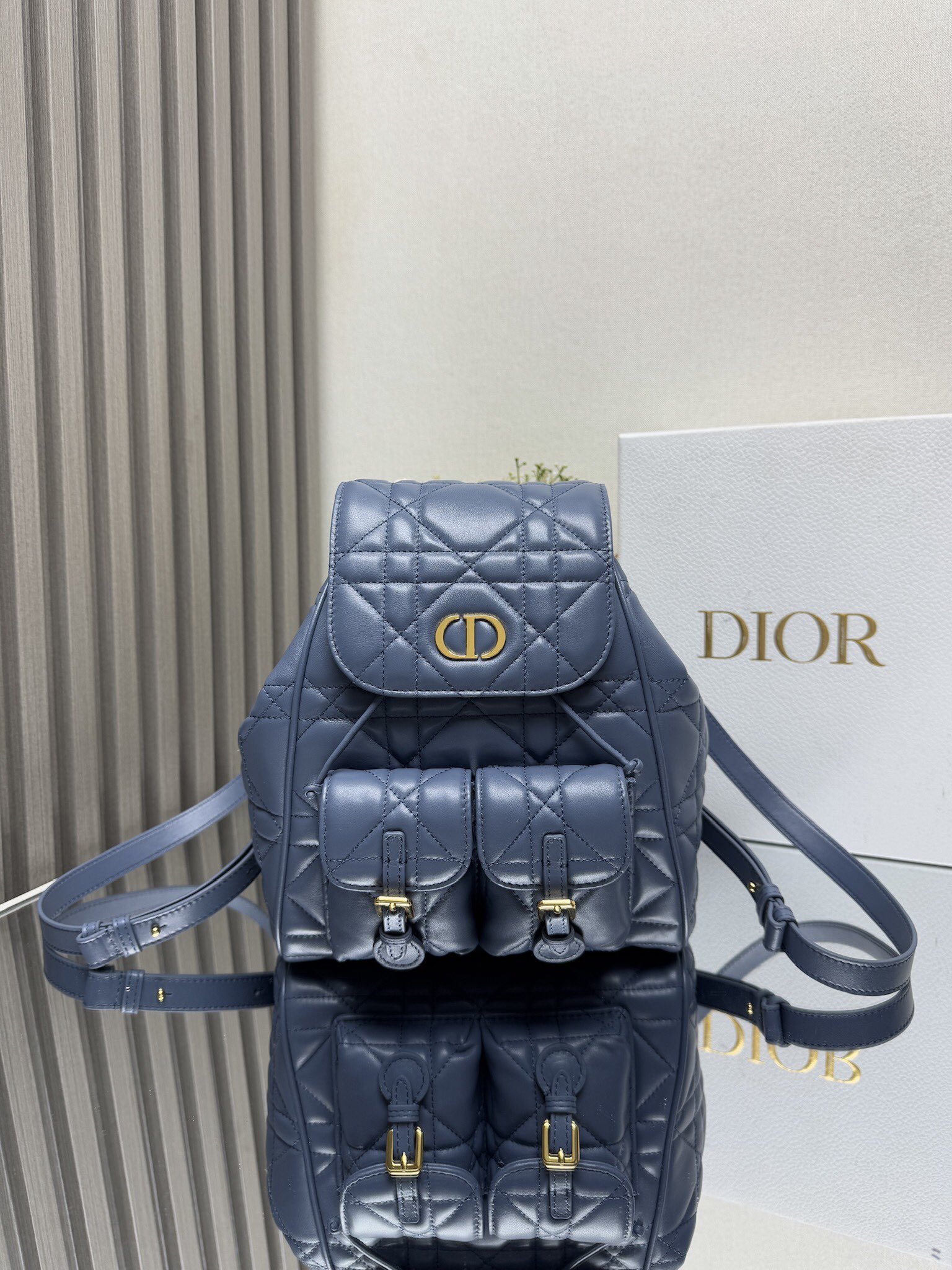 NO:771088,000720 Caro Backpack Blue Sheep Leather Oversized Cannage Product Information This Caro  The backpack is a new product of the 2025 early spring ready-to-wear series, showing a fashionable and elegant style. It is carefully made of black sheep leather and other materials, with oversized cannage pattern topstitching to enhance the style. The flap is decorated with a retro gold-finished metal CD logo. When opened, it reveals a spacious drawstring main compartment. Two small flap pockets can store various small daily necessities. The medium style is equipped with gold-finished handles and adjustable shoulder straps for added comfort. Main body: sheep leather, cow leather lining: cow leather  The front is decorated with CD logo flip cover and drawstring closure. Size 23×26.7×12.5cm. Model 6301, Dior, dior, backpacks, cowhide, sheepskin.19860909000720 Caro 双肩背包蓝色羊皮革超大藤格纹 产品信息 这款 Caro 双肩背包是二零二五早春成衣系列新品,彰显时尚优雅风范.采用黑色羊皮革等材质精心制作,搭配超大藤格纹缉面线提升格调,翻盖饰以复古金色饰面金属CD标志,打开后则是宽敞的抽绳主隔层,两个小号翻盖口袋可收纳各种小件日常用品.中号款式,搭配金色饰面手柄和可调节肩带,更添舒适. 主体:羊皮革,牛皮革里料:牛皮革 正面饰以CD 标志翻盖和抽绳开合 尺寸23×26.7×12.5cm 型号6301,迪奥,dior,backpacks,cowhide,sheepskin,Bag
