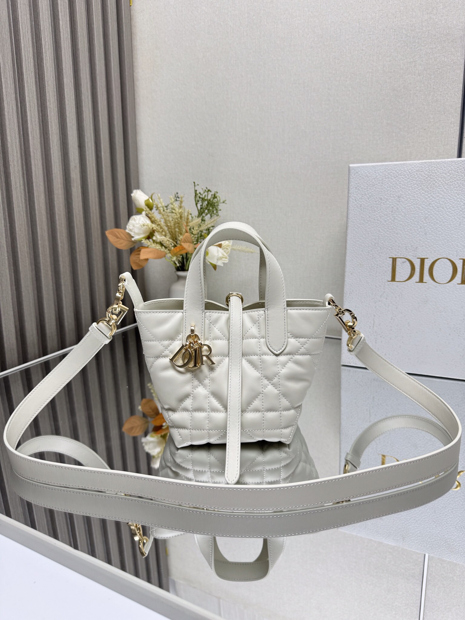 NO:209248,This miniature Toujours vertical handbag is a new product for the 2025 autumn ready-to-wear series, which is stylish and practical. It is carefully crafted from white cowhide leather, decorated with oversized rattan plaid lines, and a spacious internal compartment to store all kinds of daily necessities. It has a slim leather strap opening and closing, which can safely store all kinds of items. It also has a light gold finish metal CD Lock letter D knob buckle, which can be adjusted on both sides to enhance the style. The top leather handle is paired with a detachable leather shoulder strap, which can be carried, shoulder or crossbody. Model 2834 Size 13×15×12cm 000620, Dior, dior, cowhide19860909这款微型Toujours竖版手袋是二零二五秋季成衣系列新品,时尚实用.采用白色牛皮革精心制作,饰以超大藤格纹缉面线,宽敞的内部隔层可收纳各种日常用品.设有纤细皮革系带开合,可安全收纳各种物品,另有浅金色饰面金属CD Lock字母 D旋钮式扣环,可调节两侧,提升格调.顶部皮革手柄搭配可拆卸的皮革肩带,可手提、肩背或斜挎. 型号2834 尺寸13×15×12cm 000620,迪奥,dior,cowhide,Bag