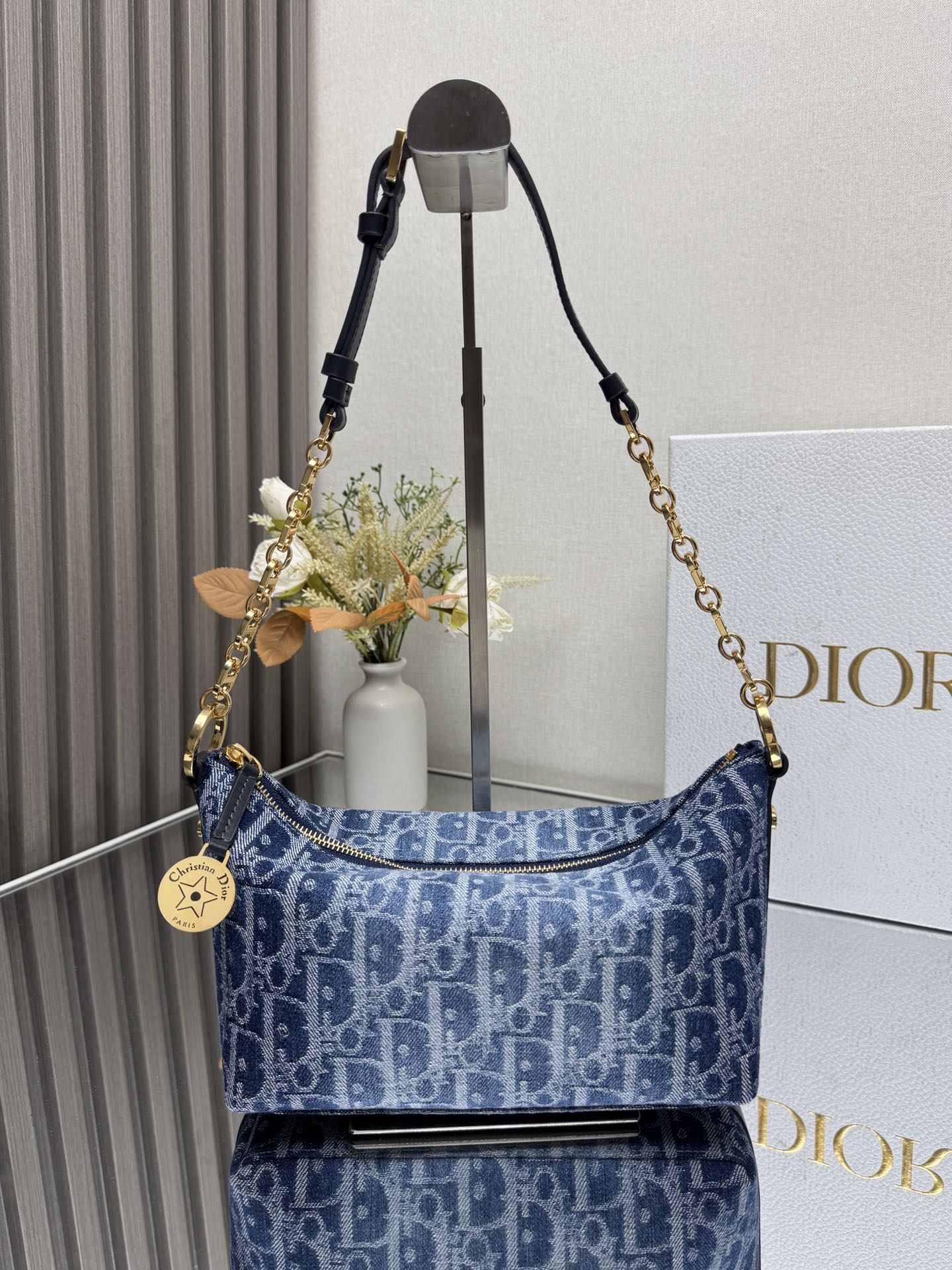 NO:387721,000450 DiorstarHobo Chain Handbag 'Denim Blue' This Diorstar Hobo Chain Handbag is a new product in the spring and summer 2024 garment series. It has a stylish shape and practical design. It is carefully crafted from jacquard fabric and is decorated with blue Oblique prints. It has a soft silhouette and a spacious compartment. Zipper closure is paired with round decorative engraved with Christian Dior aris logo and Dior classic star logo, and is decorated with exquisite CD rivets on the sides to make it look more stylish. The interior is made with suede leather lining and card slots. It is paired with adjustable CD chain shoulder straps and leather straps to enhance comfort when shoulders. Zipper closure is paired with round decorative engraved with Christian Dior aris logo and stars 1  Partitions 1 patch pocket 4 card slots Leather and gold finish metal chain link adjustable shoulder strap Model 3202 Dimensions 28.5 x 14.5 x 10 cm (L x H x W) Storage 1 cell phone, 2 card clips and sunglasses, Dior, dior, cowhide19860909000450 DiorstarHobo 链条手袋 「牛仔蓝」 这款 Diorstar Hobo 链条手袋是二零二四春夏成衣系列新品,造型时尚,设计实用.采用提花面料精心制作,饰以蓝色 Oblique 印花,廓形柔软,带有宽敞的隔层.拉链开合,搭配镌刻以 Christian Dior aris 标志和 Dior 经典星星标识的圆形饰牌,侧面饰以精致的 CD 铆钉,更显格调.内部带有绒面牛皮革里料,配有卡槽.搭配可调节的 CD 链条肩带,并带有皮革带,提升肩背时的舒适度. 拉链开合,搭配镌刻以 Christian Dior aris 标志和星星的圆形饰牌 1 个隔层 1 个贴袋 4 个卡槽 皮革和金色饰面金属链环可调节肩带 型号3202 尺寸28.5 x 14.5 x 10 厘米（长 x 高 x 宽） 可收纳 1 部手机、2 个卡夹和太阳眼镜,迪奥,dior,dior,cowhide,Bag