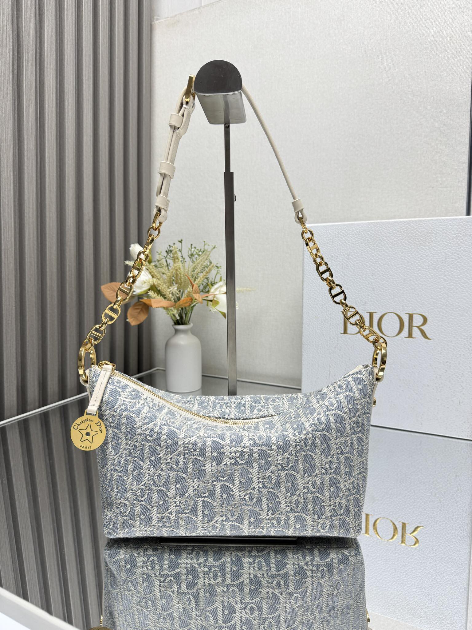 NO:387727,000450 DiorstarHobo Chain Handbag 'Bluegrass' This Diorstar Hobo Chain Handbag is a new product in the spring and summer 2024 garment series. It is stylish and practical. It is carefully crafted from jacquard fabric and decorated with blue Oblique prints. It has a soft silhouette and a spacious compartment. Zipper closure is paired with round decorative engraved with Christian Dior aris logo and Dior classic star logo, and is decorated with exquisite CD rivets on the sides to make it look more stylish. The interior is made with suede leather lining and card slots. It is paired with adjustable CD chain shoulder straps and leather straps to enhance comfort when shoulders. Zipper closure is paired with round decorative engraved with Christian Dior aris logo and stars 1  Partitions 1 patch pocket 4 card slots Leather and gold finish metal chain link adjustable shoulder strap Model 3202 Dimensions 28.5 x 14.5 x 10 cm (L x H x W) Storage 1 cell phone, 2 card clips and sunglasses, Dior, dior, cowhide19860909000450 DiorstarHobo 链条手袋 「蓝草色」 这款 Diorstar Hobo 链条手袋是二零二四春夏成衣系列新品,造型时尚,设计实用.采用提花面料精心制作,饰以蓝色 Oblique 印花,廓形柔软,带有宽敞的隔层.拉链开合,搭配镌刻以 Christian Dior aris 标志和 Dior 经典星星标识的圆形饰牌,侧面饰以精致的 CD 铆钉,更显格调.内部带有绒面牛皮革里料,配有卡槽.搭配可调节的 CD 链条肩带,并带有皮革带,提升肩背时的舒适度. 拉链开合,搭配镌刻以 Christian Dior aris 标志和星星的圆形饰牌 1 个隔层 1 个贴袋 4 个卡槽 皮革和金色饰面金属链环可调节肩带 型号3202 尺寸28.5 x 14.5 x 10 厘米（长 x 高 x 宽） 可收纳 1 部手机、2 个卡夹和太阳眼镜,迪奥,dior,dior,cowhide,Bag
