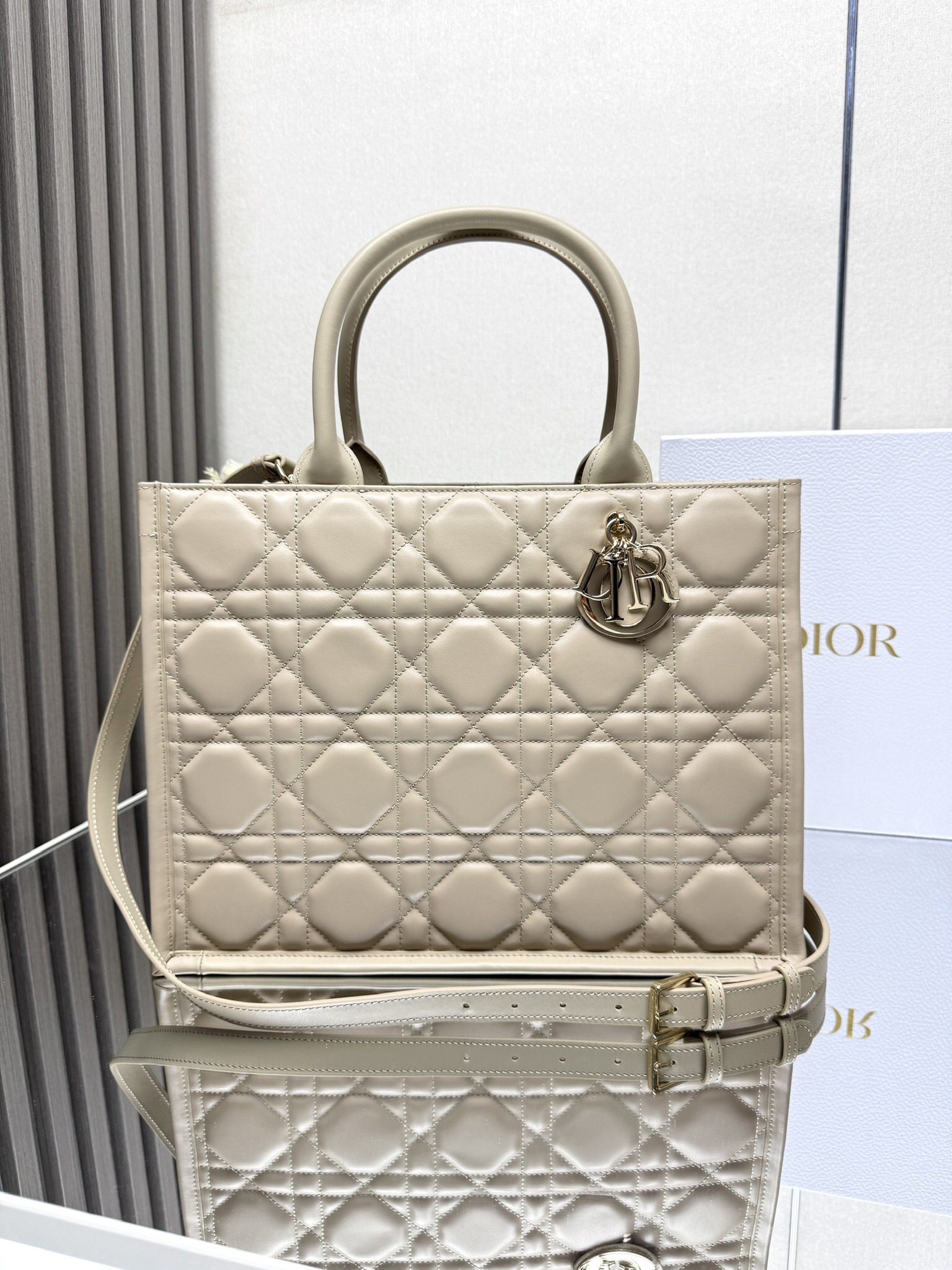 NO:387667,00650 BOOK TOTE Handbag Model: M1324 The Book Tote handbag presented by Maria Grazia Chiuri is a classic interpretation of Dior's elegance. It is carefully crafted in cowhide, highlighting the oversized rattan plaid pattern, and the handle is decorated with a light gold finish metal D.I.O.R. The interior is made of cashmere and leather, with zippered pockets and patch pockets, which can properly store all kinds of daily necessities. The light and practical style is paired with adjustable and removable shoulder straps, which highlights the exquisite craftsmanship of Dior, which can be carried or shoulder-mounted. Medium size 36.5 x 28 x 17.5 cm, Dior, dior, dior, cowhide1986090900650 BOOK TOTE 手袋 型号:M1324 由玛丽亚·嘉茜娅·蔻丽 (Maria Grazia Chiuri) 呈献的 Book Tote 手袋优良体现了 Dior 对优雅的经典诠释.采用牛皮革精心制作,突显超大藤格纹图案,手柄饰以浅金色饰面金属 D.I.O.R 吊饰.内部采用山羊绒和皮革材质,设有拉链口袋和贴袋,可妥善收纳各种日常用品.轻盈实用的款式搭配可调节、可拆卸肩带,彰显 Dior 的精湛工艺,可手提或肩背. 中号尺寸36.5 x 28 x 17.5 厘米,迪奥,dior,dior,cowhide,Bag