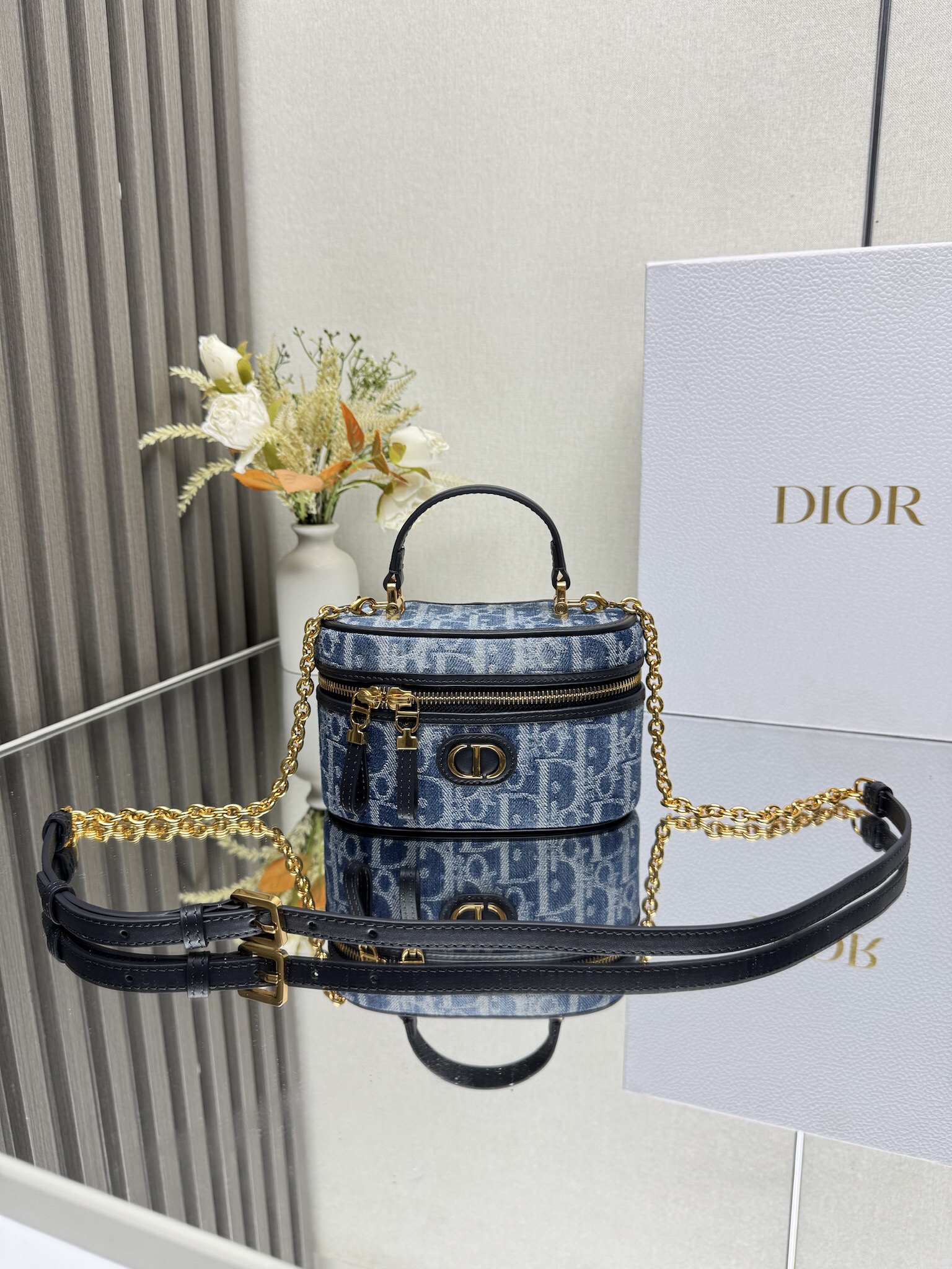NO:557357,000480 Dior's new 30 Montaigne mini Vanity handbag 'Denim Blue' This 30 Montaigne mini Vanity handbag is exquisitely designed, combining practical function and elegance, enhancing the style of the series. It is carefully made of blue Oblique printed fabric and is decorated with CD on the front.  Signature enhances style. It can store all your daily essentials and features an interior pocket and mirror for added sophistication. Carry it by the handle and features an adjustable shoulder strap made of alternating gold-finished metal and blue enamel links with leather inserts. Can be worn on the shoulder or cross-body. CD logo on the front Zip closure with CD puller Top handle 1 compartment with mirror Internal patch pocket Adjustable, removable leather shoulder strap Model   Dimensions 16.5 x 8 x 9.5 cm (length x height x width) Can store 1 mobile phone, 1 card holder and lipstick, Dior, dior, dior19860909000480 Dior新款30 Montaigne 迷你 Vanity 手袋「牛仔蓝布」 这款 30 Montaigne 迷你 Vanity 手袋设计精巧,兼具实用功能与高雅气质,为该系列提升格调.采用蓝色 Oblique 印花面料精心制作,正面饰以 CD 标志提升格调.可收纳各种日常用品,设有一个内部口袋和镜子,更显精致.可通过手柄手提,搭配可调节肩带,以金色饰面金属和蓝色珐琅链环相间交错打造,饰以皮革镶片,可肩背或斜挎. 正面饰以 CD 标志 拉链开合搭配 CD 拉链头 顶部手柄 1 个隔层搭配镜子 内部贴袋 可调节、可拆卸的皮革肩带 型号 尺寸16.5 x 8 x 9.5 厘米（长 x 高 x 宽） 可收纳 1 部手机、1 个卡夹和唇膏,迪奥,dior,dior,Bag