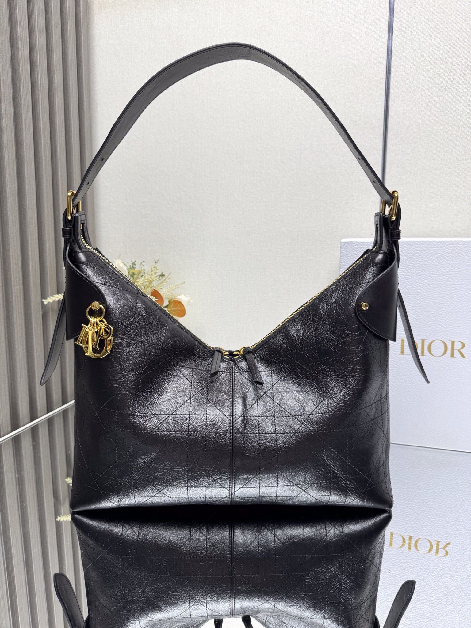 NO:659346,Large Dior Voyage Handbag 'Pleated Black' This Dior Voyage handbag is a new product in the 2026 Early Spring ready-to-wear series. It combines soft lines and elegant details to create a harmonious dumpling bag silhouette. It is carefully made of black pleated cow leather and decorated with flat oversized cannage topstitching, which reinterprets Dior's classic pattern. The soft silhouette is paired with gold-finished metal D.I.O.R.  Charms and expertly crafted leather accents enhance the style and make the look wider, while the main compartment features a safe and practical two-way zipper closure. The large style has an adjustable top handle with buckle that can be worn on the shoulder, making it an ideal companion for everyday looks. Two-way zipper closure D.I.O.R. charm Adjustable leather top handle with gold-finish metal buckle Internal zipper pocket Model 16963 (2844) Dimensions 34 x 22 x  13 cm (L x H x W) Holds 1 small bag, 1 wallet, 1 mobile phone, 1 card holder, sunglasses and lipstick 0000680,Dior,dior,dior,wallets,cowhide19860909大号 Dior Voyage 手袋「褶皱黑色」 这款 Dior Voyage 手袋是二零二六早春成衣系列新品,融合柔软线条和高雅的细节,打造协调的水饺包廓形.采用黑色褶皱牛皮革精心制作,饰以扁平超大藤格纹缉面线,焕新演绎 Dior 的经典图案.柔软廓形搭配金色饰面金属 D.I.O.R. 吊饰和匠心打造的皮革点缀提升格调,令造型更加挺阔,主隔层则采用安全实用的双向拉链开合.大号款式,顶部手柄搭配可调节搭扣,可肩背,是日常造型的理想良伴. 双向拉链开合 D.I.O.R. 吊饰 可调节顶部皮革手柄,搭配金色饰面金属搭扣 内部拉链口袋 型号16963（2844） 尺寸34 x 22 x 13 厘米（长 x 高 x 宽） 可收纳 1 个小包、 1 个钱包、1 部手机、1 个卡夹、太阳眼镜和唇膏 0000680,迪奥,dior,dior,wallets,cowhide,Bag