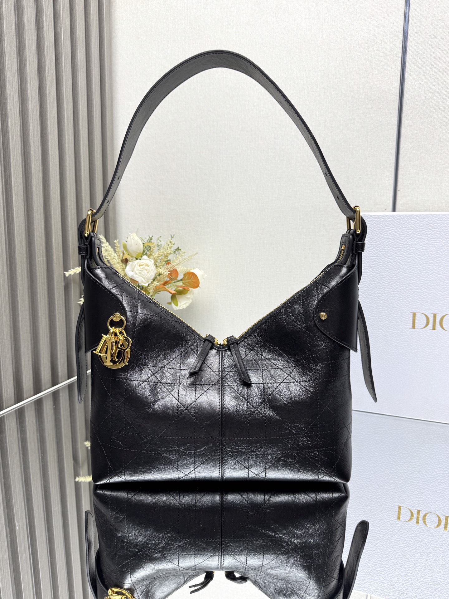 NO:659341,Medium Dior Voyage Handbag 'Pleated Black' This Dior Voyage handbag is a new product in the 2026 Early Spring ready-to-wear series. It combines soft lines and elegant details to create a coordinated silhouette. It is carefully made of black pleated cow leather and decorated with flat oversized cannage topstitching, which reinterprets Dior's classic pattern. The soft silhouette is paired with gold-finished metal D.I.O.R.  The charm and expertly crafted leather accents enhance the style and make the look wider, while the main compartment features a secure and practical two-way zipper closure. The medium model has an adjustable top handle with buckle that can be worn over the shoulder, making it ideal for everyday styling. Two-way zipper closure D.I.O.R. Charm Adjustable leather top handle with gold-finish metal buckle Internal zippered pocket Model 16960 () Dimensions 28 x 18 x 12 cm (Length)  x height x width) Holds 1 tablet, 1 Voyageur slim wallet, 1 card holder, 1 mobile phone, sunglasses and lipstick 000620,Dior,dior,dior,wallets,cowhide19860909中号 Dior Voyage 手袋「褶皱黑色」 这款 Dior Voyage 手袋是二零二六早春成衣系列新品,融合柔软线条和高雅的细节,打造协调的廓形.采用黑色褶皱牛皮革精心制作,饰以扁平超大藤格纹缉面线,焕新演绎 Dior 的经典图案.柔软廓形搭配金色饰面金属 D.I.O.R. 吊饰和匠心打造的皮革点缀提升格调,令造型更加挺阔,主隔层则采用安全实用的双向拉链开合.中号款式,顶部手柄搭配可调节搭扣,可肩背,是日常造型的理想良伴. 双向拉链开合 D.I.O.R. 吊饰 可调节顶部皮革手柄,搭配金色饰面金属搭扣 内部拉链口袋 型号16960 () 尺寸28 x 18 x 12 厘米（长 x 高 x 宽） 可收纳 1 个平板电脑、1 个 Voyageur 细窄钱包、1 个卡夹、1 部手机、太阳眼镜和唇膏 000620,迪奥,dior,dior,wallets,cowhide,Bag