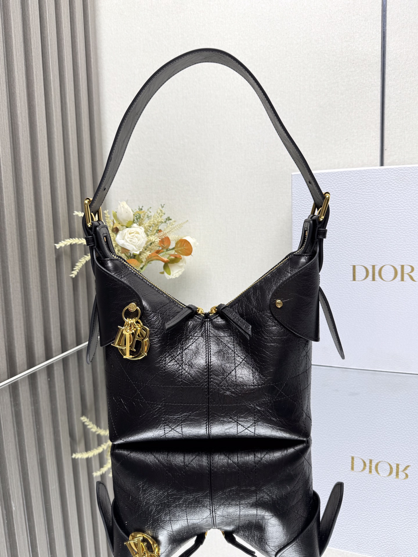 NO:659344,Small Dior Voyage Handbag 'Pleated Black' This Dior Voyage handbag is a new product in the 2026 Early Spring ready-to-wear series. It combines soft lines and elegant details to create a coordinated silhouette. It is carefully made of black pleated cow leather and decorated with flat oversized cannage topstitching, which reinterprets Dior's classic pattern. The soft silhouette is paired with gold-finished metal D.I.O.R.  Charms and expertly crafted leather accents enhance the style and make the look wider, while the main compartment features a secure and practical two-way zipper closure. The small version features an adjustable top handle with buckle that can be worn over the shoulder, making it ideal for everyday styling. Two-way zipper closure D.I.O.R. Charm Adjustable leather top handle with gold-finish metal buckle Internal zippered pocket Model 16961 (2846) Dimensions 22 x 15 x  9.5 cm (L x H x W) Holds 1 Voyageur slim wallet, 1 card holder, 1 mobile phone, sunglasses and lipstick 000580,Dior,dior,dior,wallets,cowhide19860909小号 Dior Voyage 手袋「褶皱黑色」 这款 Dior Voyage 手袋是二零二六早春成衣系列新品,融合柔软线条和高雅的细节,打造协调的廓形.采用黑色褶皱牛皮革精心制作,饰以扁平超大藤格纹缉面线,焕新演绎 Dior 的经典图案.柔软廓形搭配金色饰面金属 D.I.O.R. 吊饰和匠心打造的皮革点缀提升格调,令造型更加挺阔,主隔层则采用安全实用的双向拉链开合.小号款式,顶部手柄搭配可调节搭扣,可肩背,是日常造型的理想良伴. 双向拉链开合 D.I.O.R. 吊饰 可调节顶部皮革手柄,搭配金色饰面金属搭扣 内部拉链口袋 型号16961 (2846) 尺寸22 x 15 x 9.5 厘米（长 x 高 x 宽） 可收纳 1 个 Voyageur 细窄钱包、1 个卡夹、1 部手机、太阳眼镜和唇膏 000580,迪奥,dior,dior,wallets,cowhide,Bag