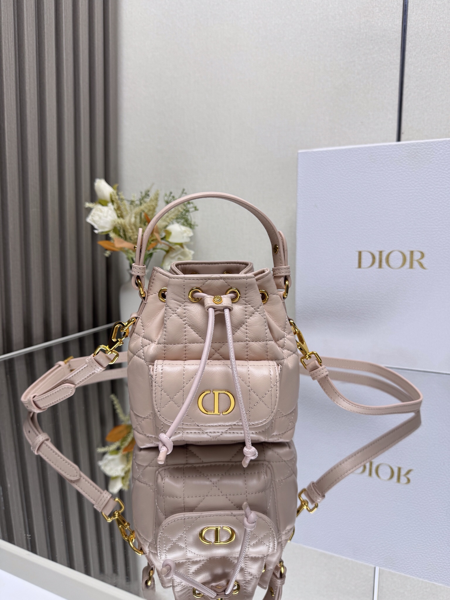 NO:659359,This miniature Dior Caro bucket bag is a new addition to the Fall 2025 ready-to-wear collection, emphasizing fashionable elegance. It is crafted from black sheepskin, decorated with oversized cannage pattern topstitching, and has a drawstring compartment. The front flap pocket is decorated with a vintage gold-finish metal CD logo, which can store a variety of small daily necessities. Fashionable and versatile, with a detachable top handle and an adjustable and detachable shoulder strap, it can be carried by hand, shoulder or cross-body.  CD logo drawstring closure on the front Magnetic flap pocket on the front Internal slip pocket Detachable leather handle on top Adjustable, detachable leather shoulder strap with dust bag included Size 14*15*7cm Made in Italy Model number: Mini pink 000550, Dior, dior, dior, sheepskin19860909这款微型 Dior Caro 水桶包是二零二五秋季成衣系列新品,彰显时尚优雅风范.采用黑色羊皮革精心制作,饰以超大藤格纹缉面线,设有一个抽绳隔层.正面翻盖口袋饰以复古金色饰面金属CD 标志,可收纳各种小件日常用品.时尚百搭,搭配可拆卸顶部手柄和可调节、可拆卸的肩带,可手提、肩背或斜挎. 正面饰以CD标志抽绳开合 正面磁性翻盖口袋内部插袋 顶部可拆卸皮革手柄 可调节、可拆卸的皮革肩带内含防尘袋 尺寸14*15*7cm 意大利制造 型号: 迷你粉色 000550,迪奥,dior,dior,sheepskin,Bag