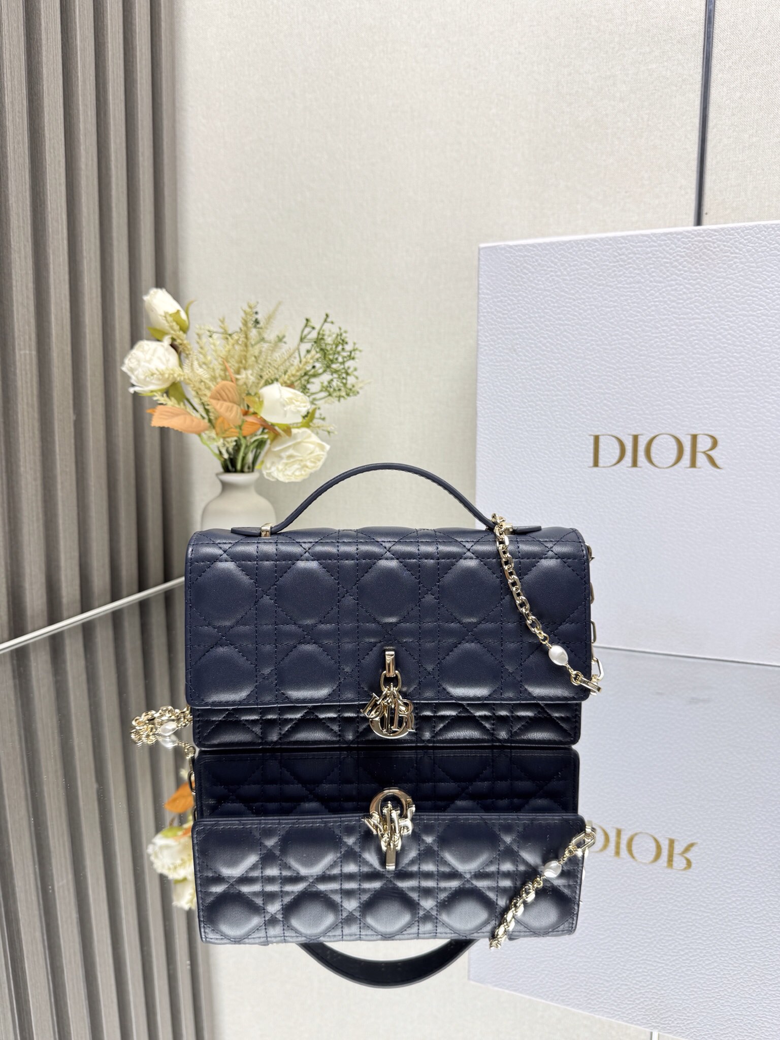 NO:720067,000550 lady Dior pearl clutch 'Dark Blue Sheepskin' This clutch is new this season with a handle on the top. It is elegant and practical, making Lady Dior  The series is enriched. It is carefully made of black sheep leather and decorated with cannage pattern. The clamshell design is matched with D.I.O.R. charms to enhance the style. The style is practical and equipped with multiple compartments and card slots to store various daily necessities. It is an ideal companion for day and evening wear. The top handle and detachable chain are embellished with beads for more exquisiteness. It can be carried by hand or cross-body. Model 0809 Dimensions 21 x 11.5 x 4.5cm  D.I.O.R. charm on the front Flap closure 2 interior compartments Rear patch pocket 3 card slots Top leather handle Removable chain embellished with beads, Dior, dior, dior, handbag, sheepskin19860909000550 lady Dior 珍珠手拿包 「深蓝色羊皮」 这款手拿包是本季新品顶部搭配手柄,优雅实用,令 Lady Dior 系列更加丰富.采用黑色羊皮革精心制作,饰以藤格纹,翻盖设计搭配D.I.O.R.吊饰提升格调.款式实用,设有多个隔层和卡槽,可收纳各种日常用品,是日装和晚装的理想良伴.顶部手柄,可拆卸链条以珠饰点缀更显精致,可手提或斜挎. 型号0809 尺寸21 x 11.5 x 4.5cm 正面D.I.O.R.吊饰 翻盖开合 2 个内部隔层 后侧贴袋 3 个卡槽 顶部皮革手柄 可拆卸的链条点缀以珠饰,迪奥,dior,dior,handbag,sheepskin,Bag