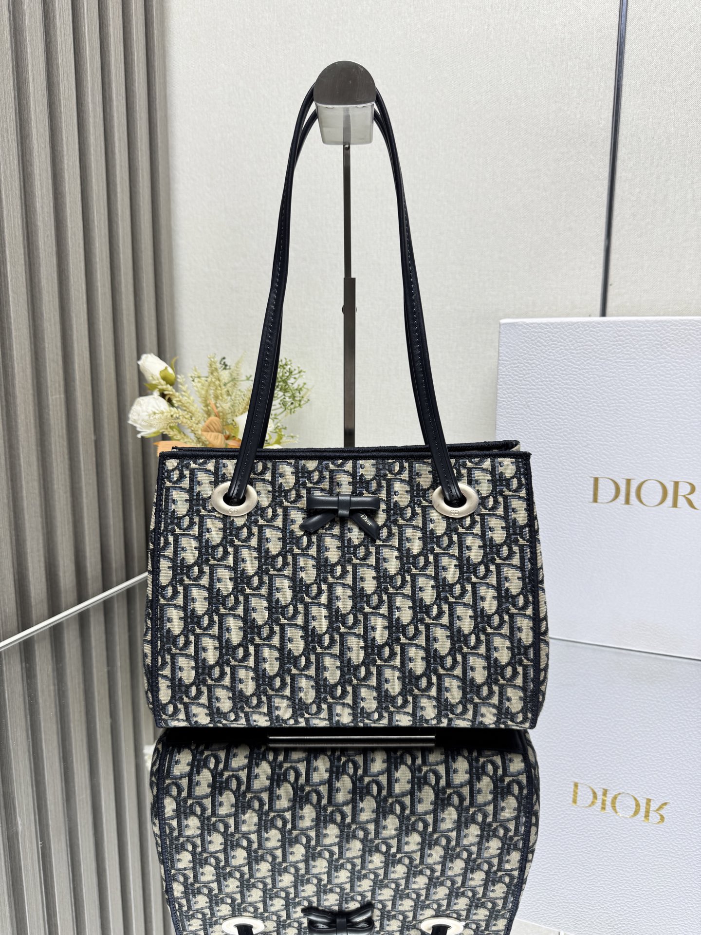 NO:773369,Dior's new small shopping bag This shopping bag was created by Jonathan Anderson for Dior. Its practical and spacious design is enhanced by a delicate bow, showing Dior's new signature details. The small style combines materials such as Oblique printed fabrics and leather trims. Its soft silhouette and clever sliding top handle make it unique. It can be carried by hand, shoulder or cross-body. Magnetic closure Dior signature leather bow on the front  Sliding top leather handle with CD logo eyelet Internal zip pocket Internal slip pocket Model Dimensions 27 x 19 x 13.5 cm (L x H x W) Holds 1 wallet, 1 mobile phone, 1 card holder, sunglasses and lipstick 238520,Dior,dior,dior,wallets19860909Dior新款小号购物袋 这款购物袋由乔纳森·安德森 (Jonathan Anderson) 为 Dior 倾情打造,实用宽敞的设计饰以精美蝴蝶结提升格调,展现 Dior 的全新标志细节.小号款式,将 Oblique 印花面料和皮革装饰等材质巧妙结合,柔软廓形和巧妙的滑动式顶部手柄别具一格,可手提、肩背或斜挎. 磁性开合 正面饰以 Dior 标志皮革蝴蝶结 顶部滑动式皮革手柄,搭配 CD 标志孔眼 内部拉链口袋 内部插袋 型号 尺寸27 x 19 x 13.5 厘米（长 x 高 x 宽） 可收纳 1 个钱包、1 部手机、1 个卡夹、太阳眼镜和唇膏 238520,迪奥,dior,dior,wallets,Bag